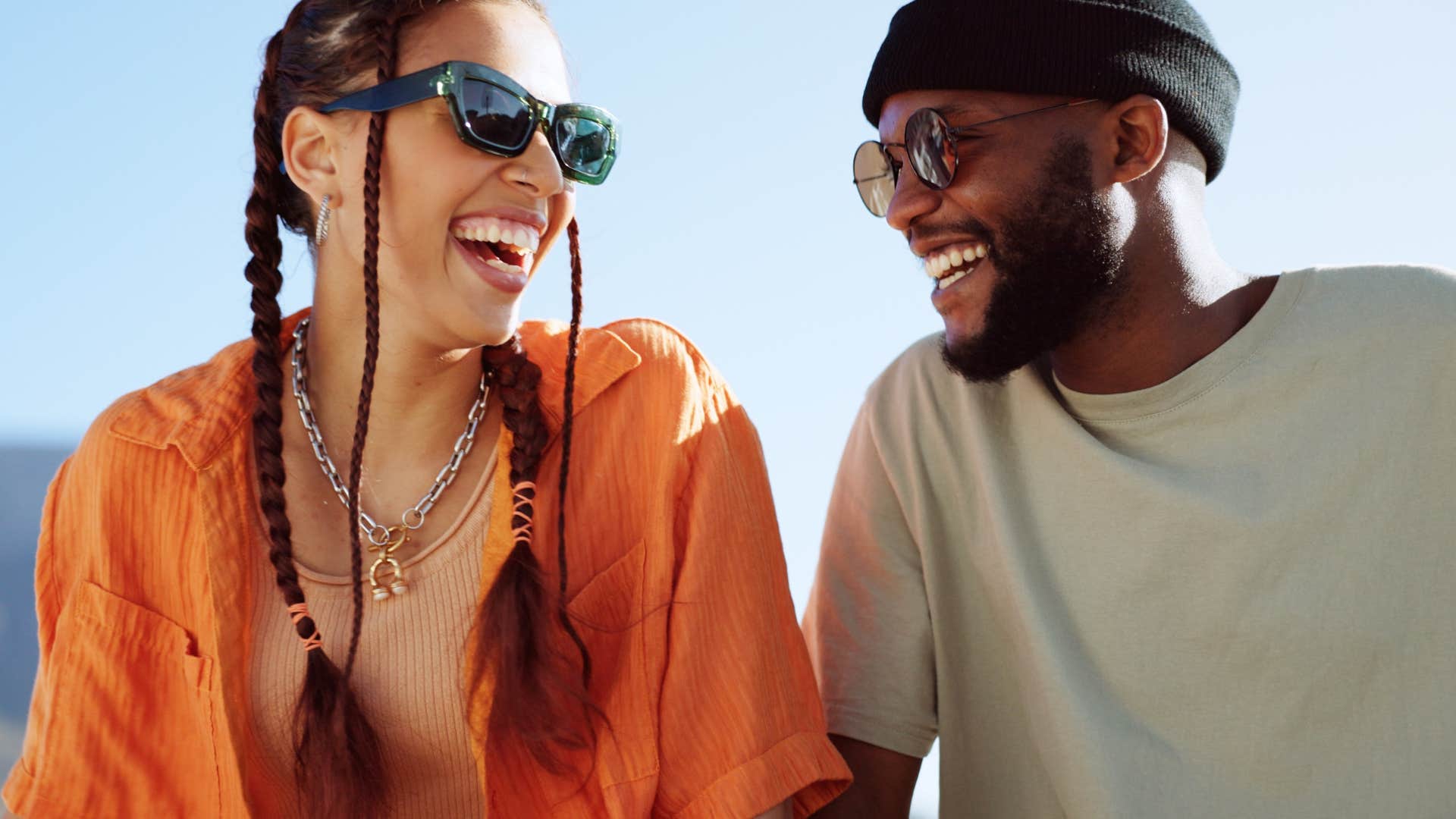 Gen Z friends smiling and laughing together outside.