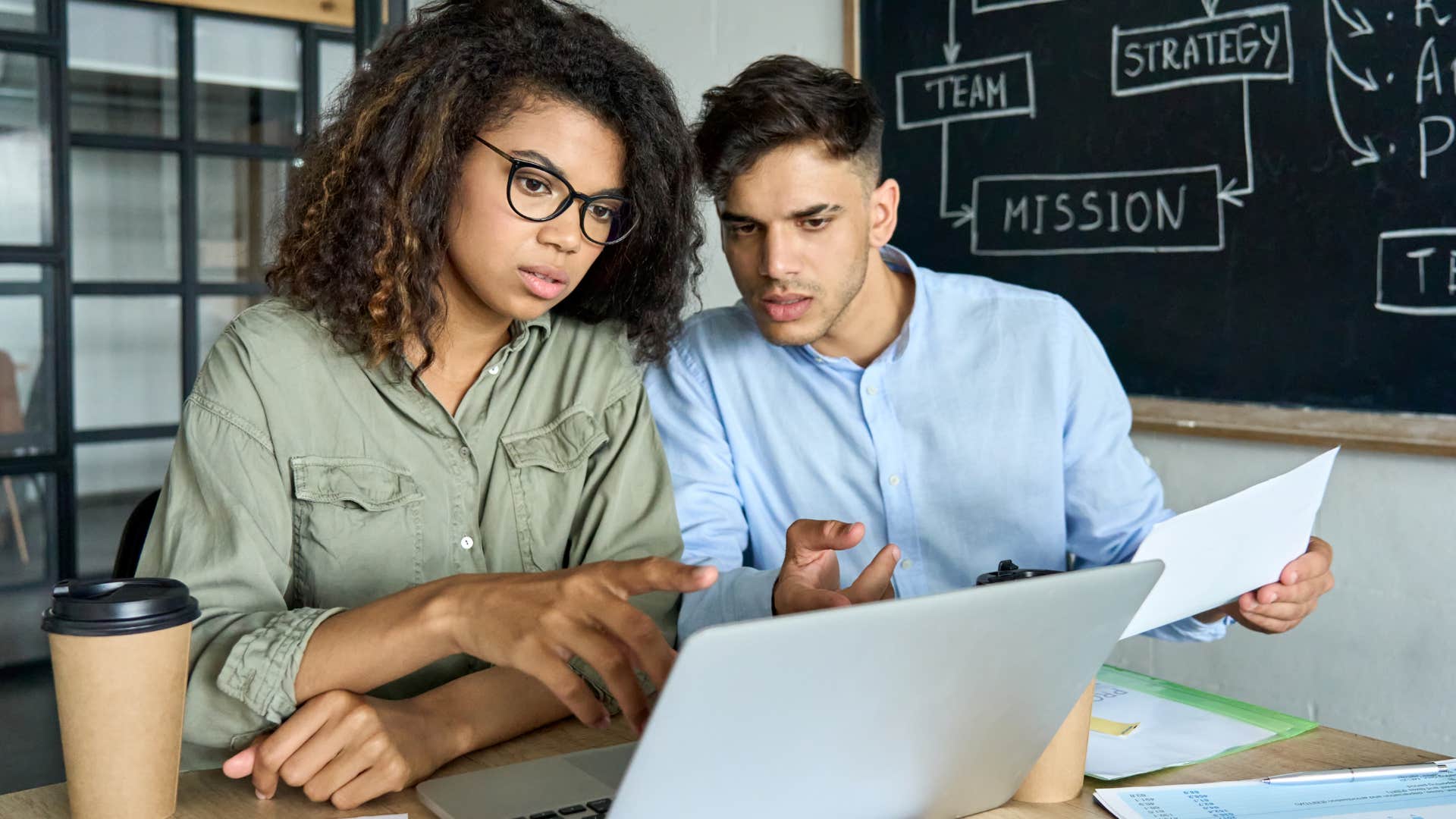 Gen Z workers looking tired staring at their laptop.