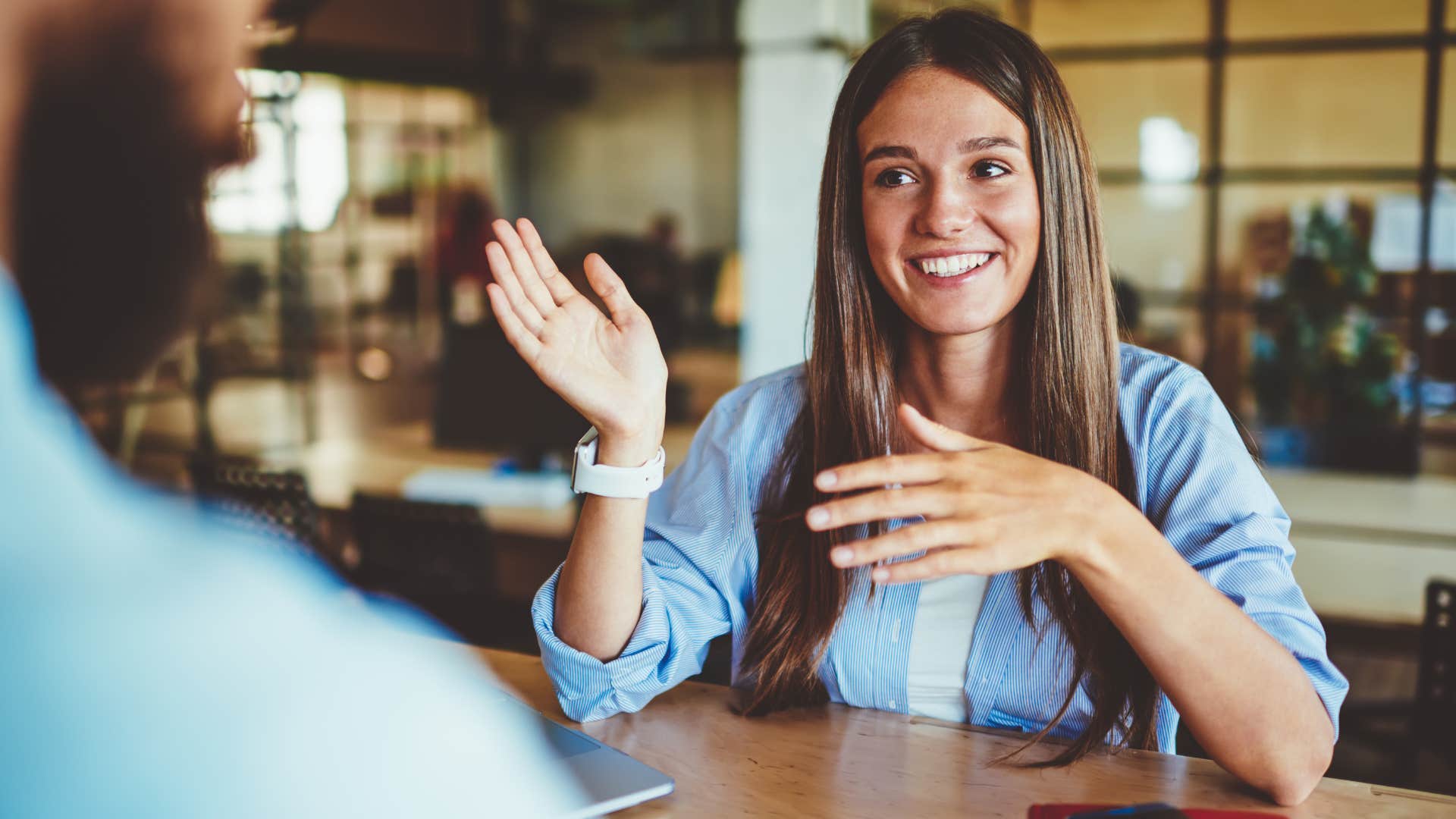 Woman smiling while talking to a man