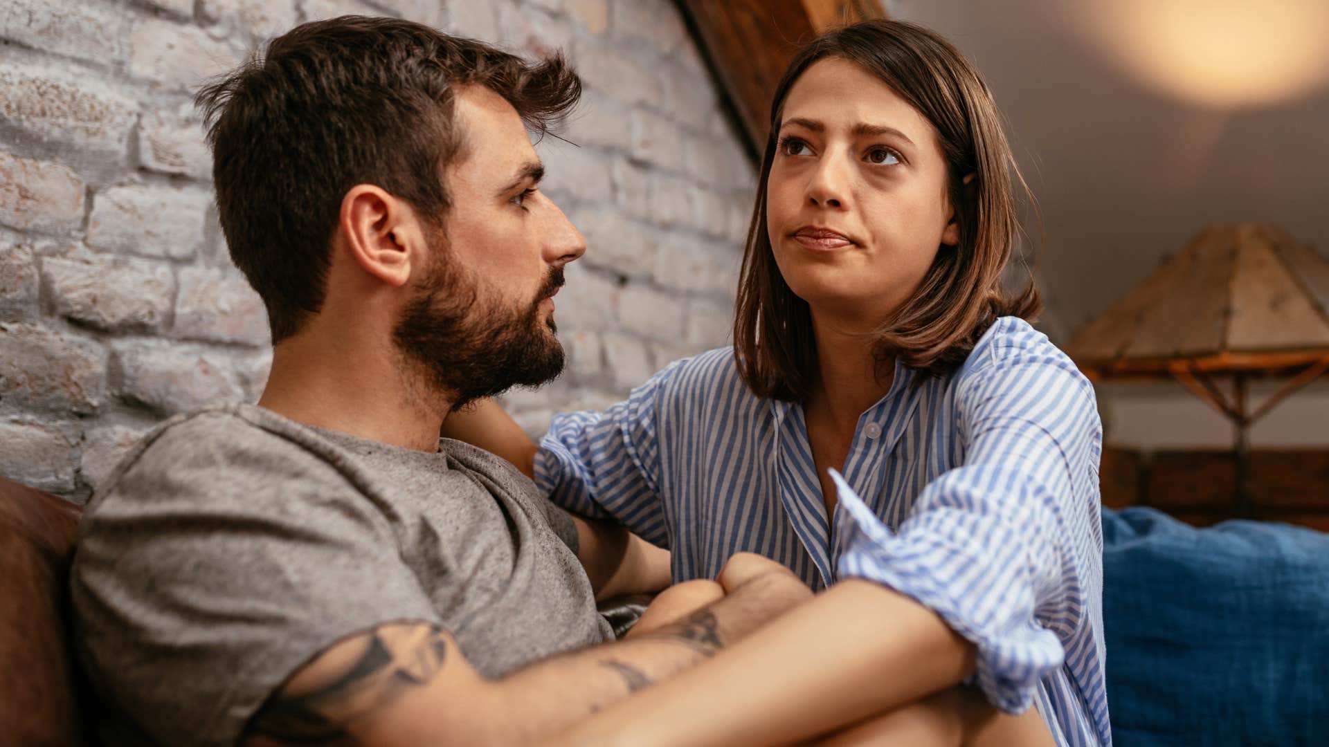 Woman hugging her husband on the couch.