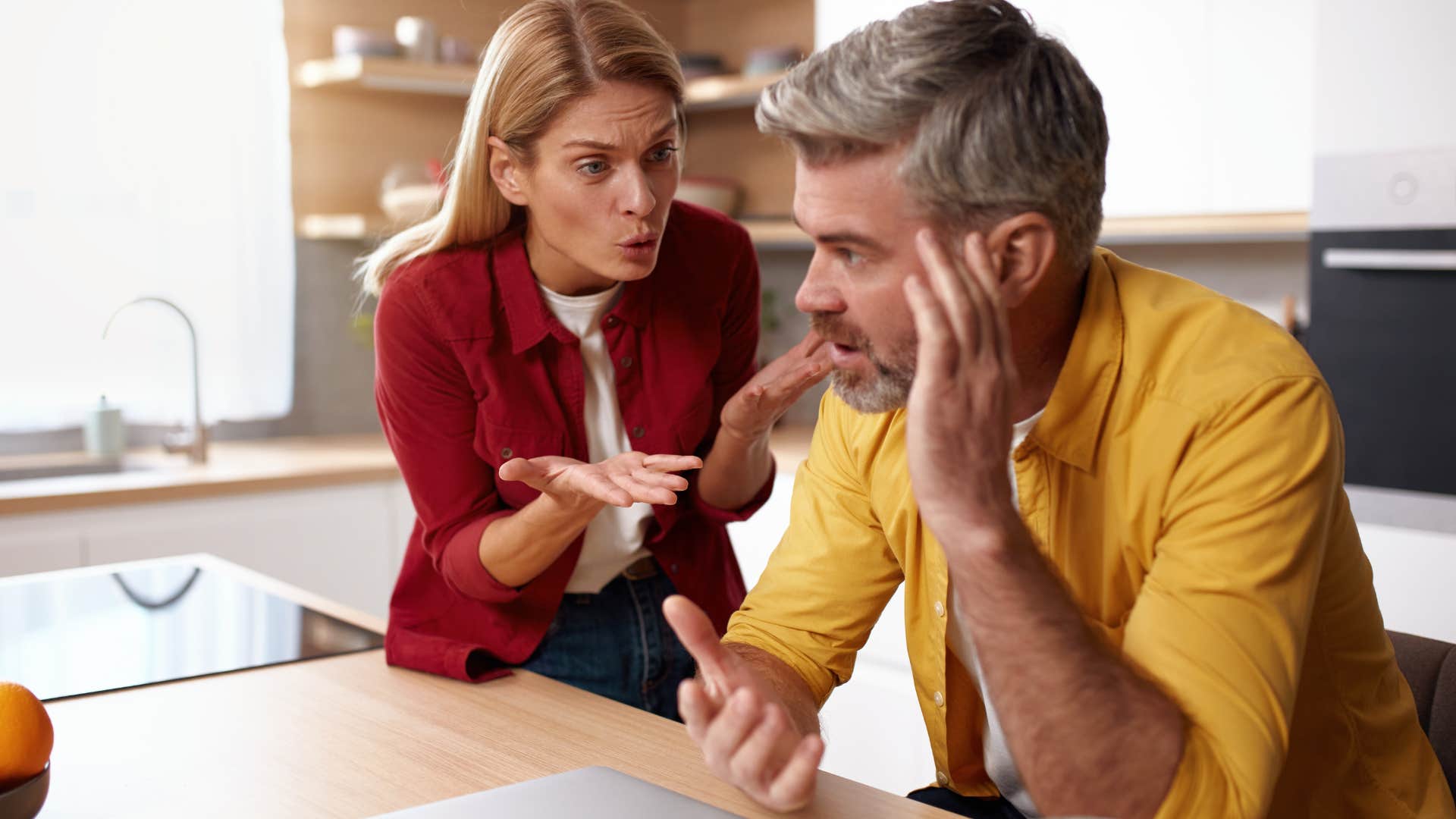 Man holding his head while his wife yells at him.