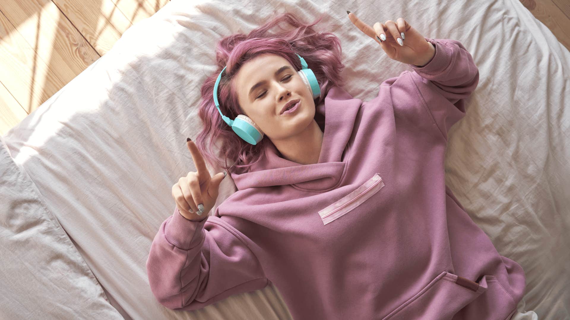 woman with pink hair listening to music