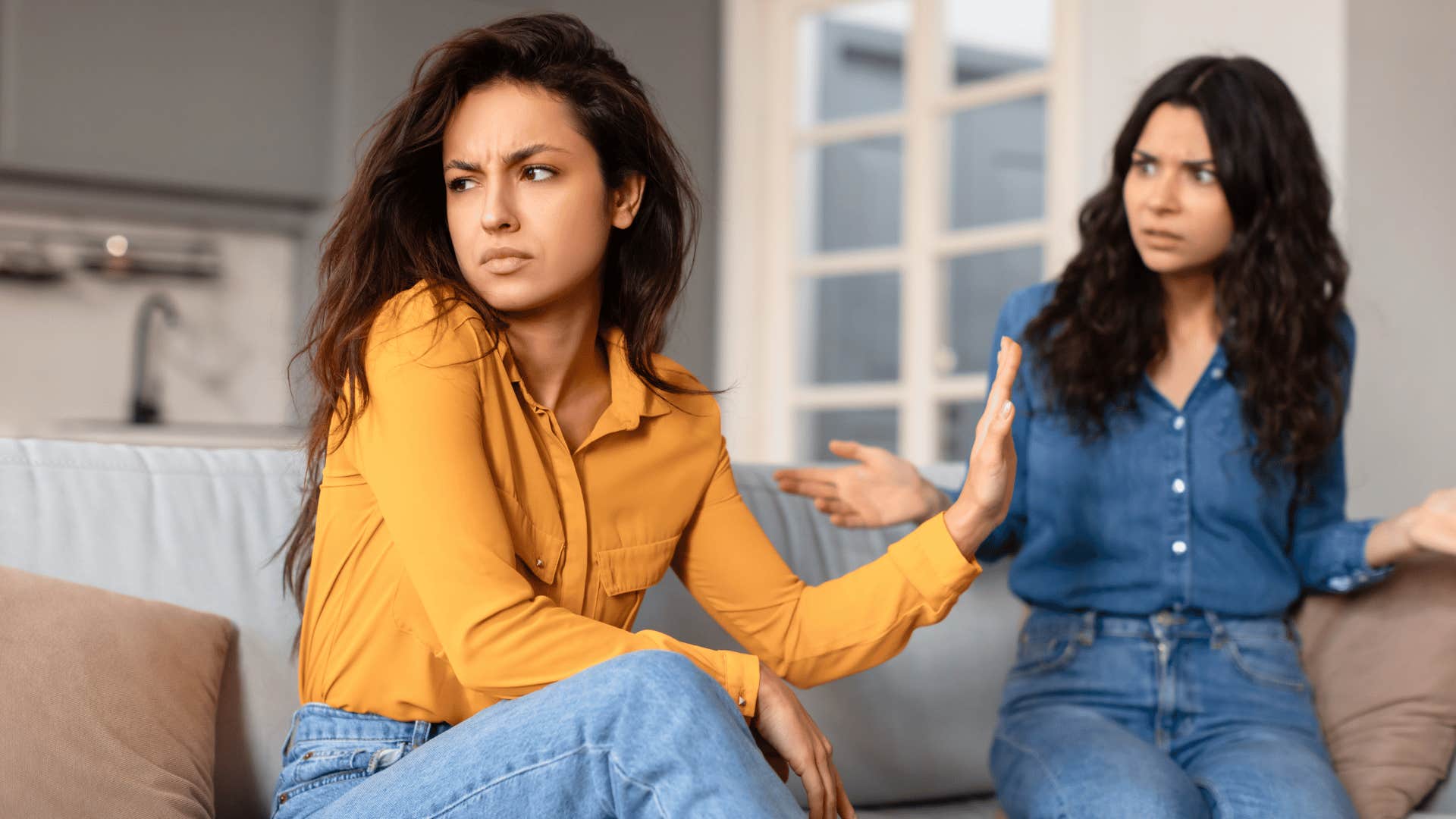 woman holding up hand to other woman