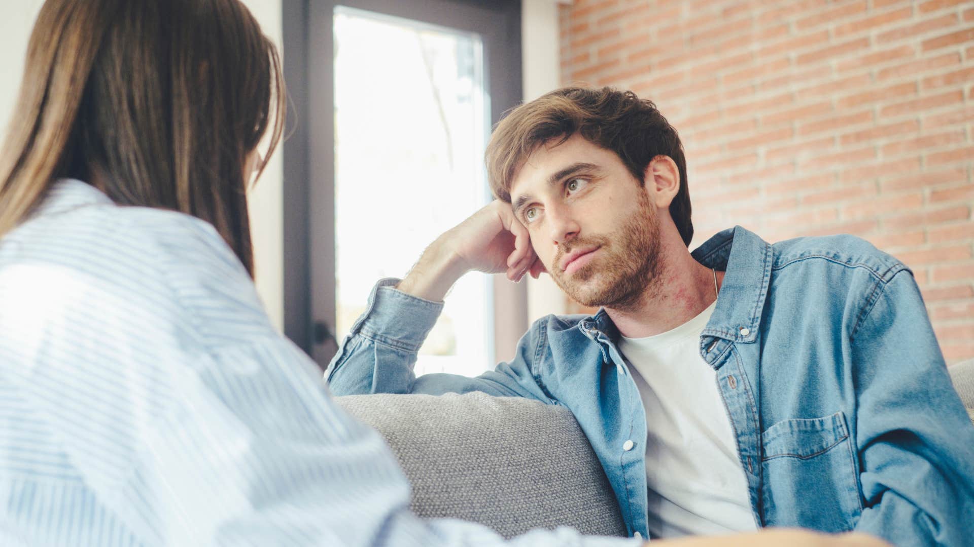 man looking at woman who is trying to blame him