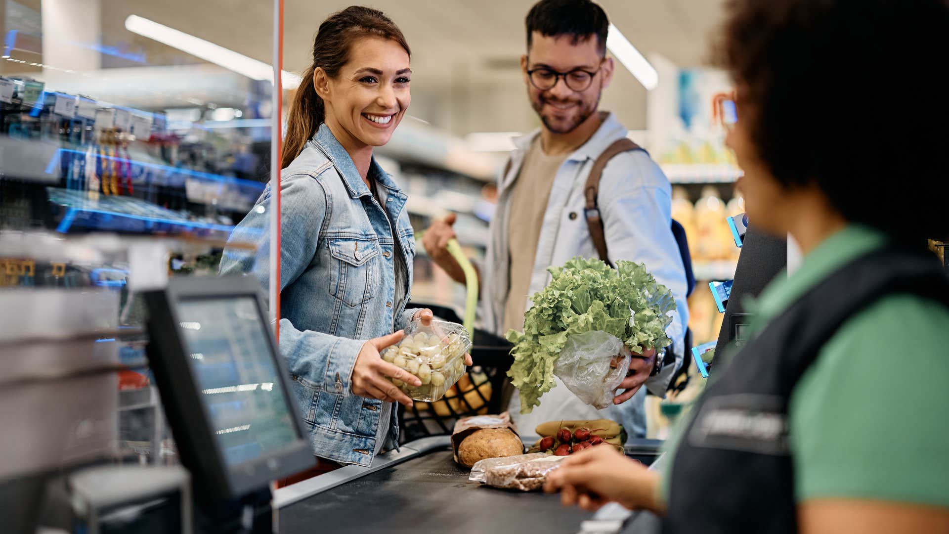 Woman checking out in a grocery store line.