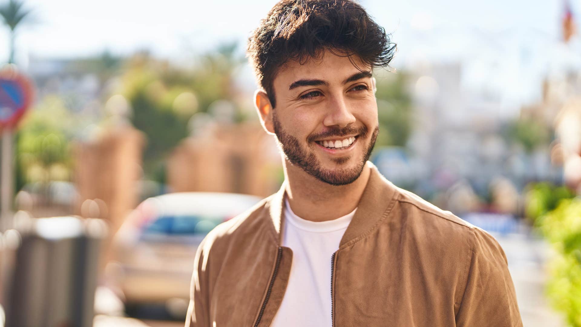 Man smiling while walking outside.