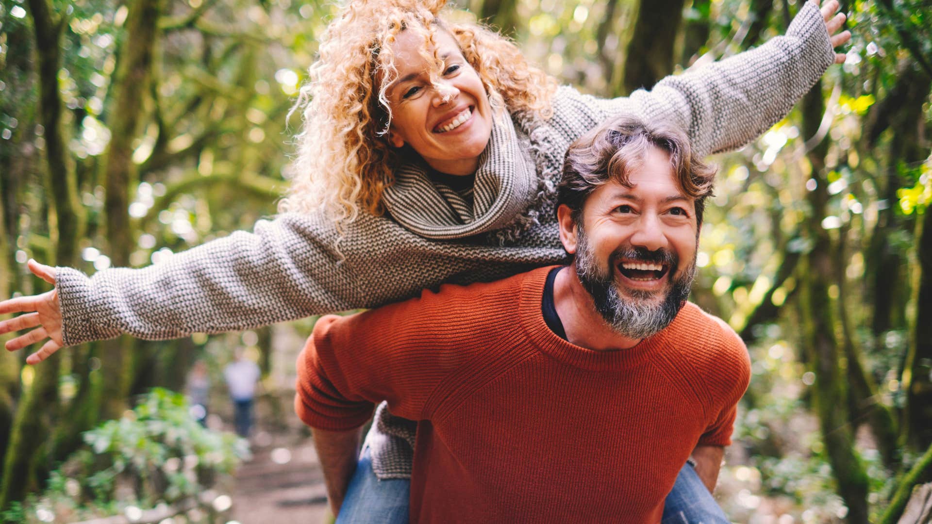 Man carrying around a smiling woman on his back.