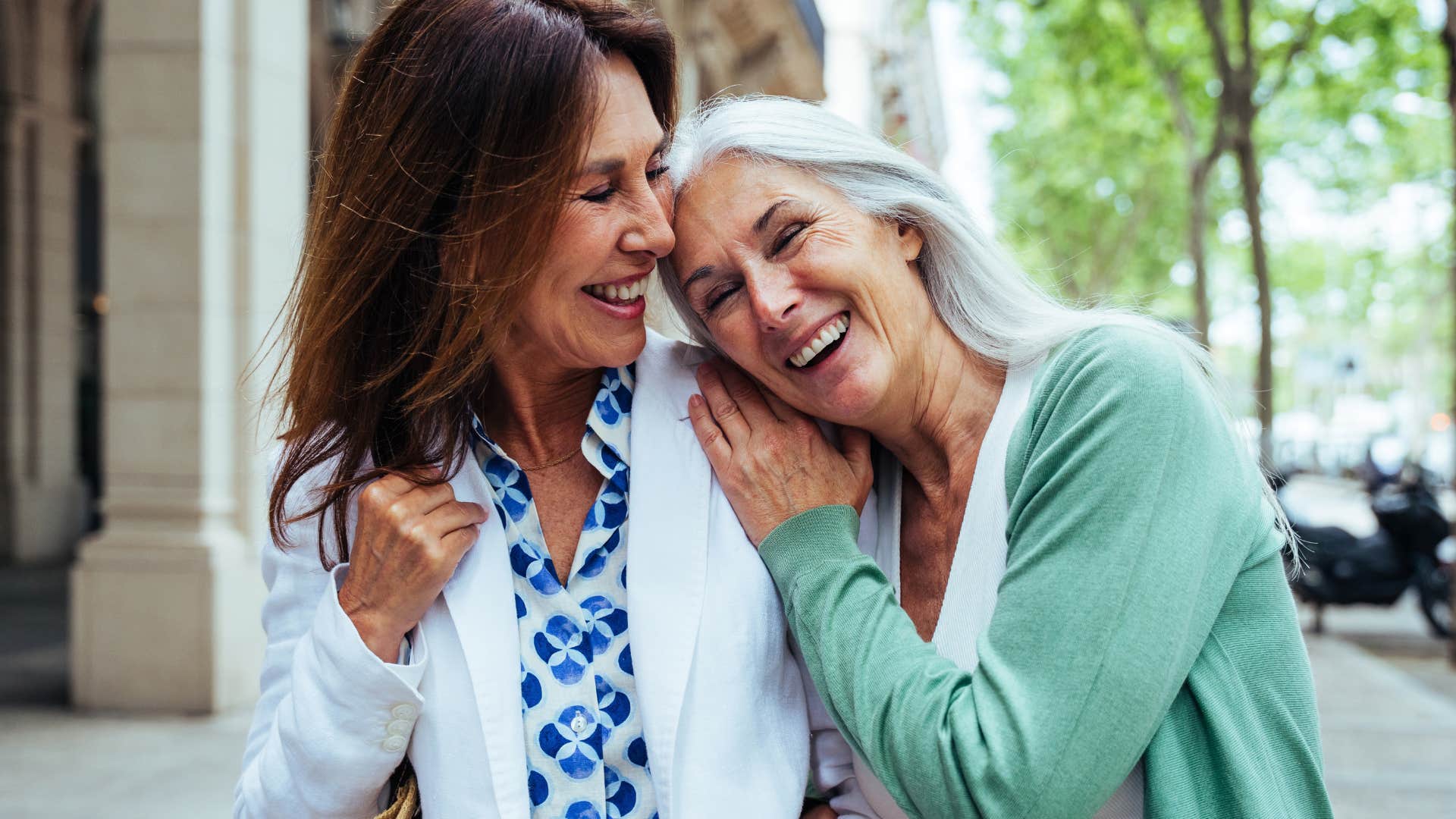 Two older women smiling and laughing together.