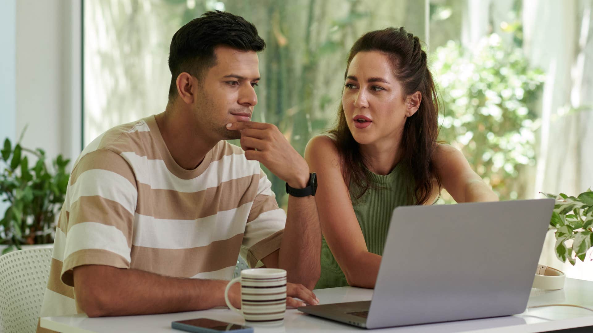 Woman sitting at her computer next to her boyfriend.