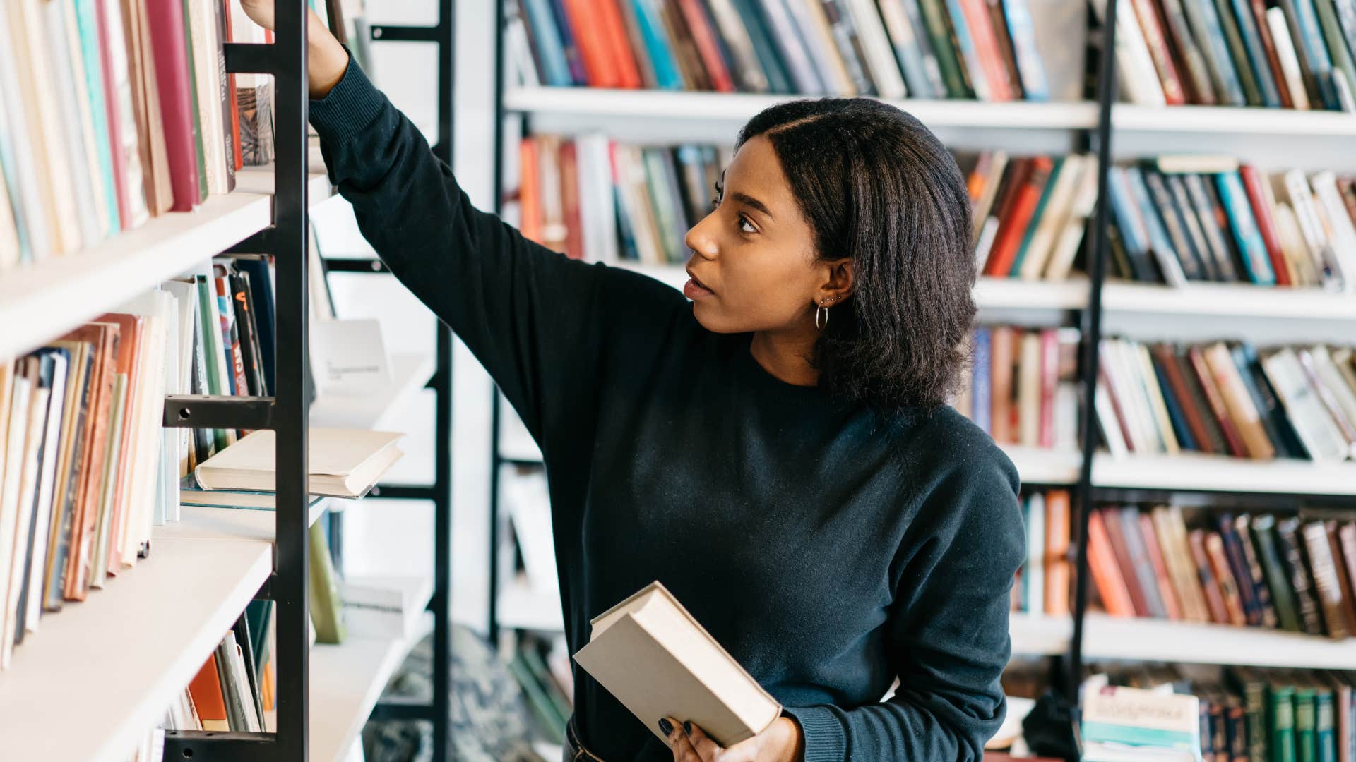 Woman looking through books in a library