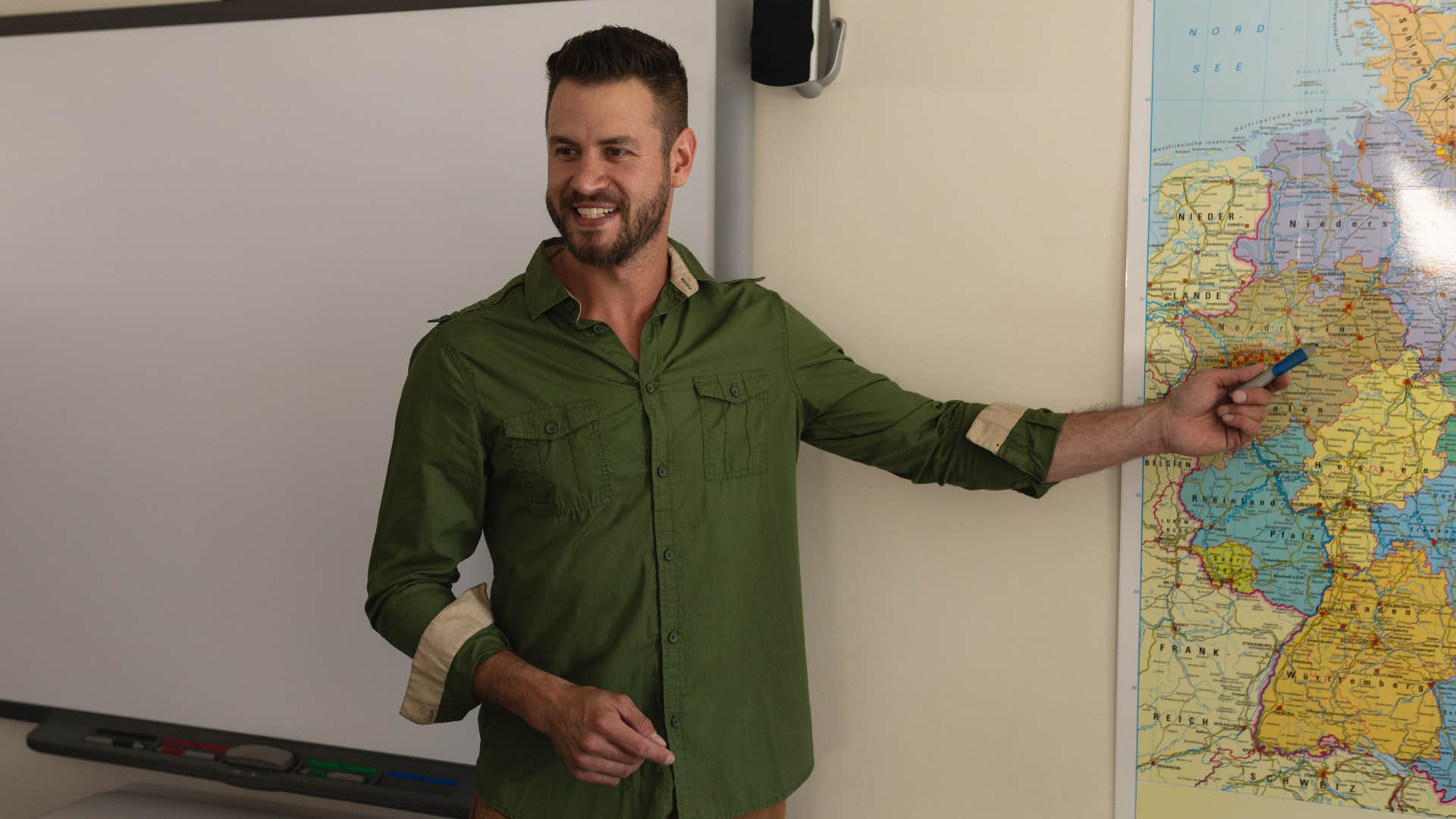 Teacher pointing at a pull-down map on the wall