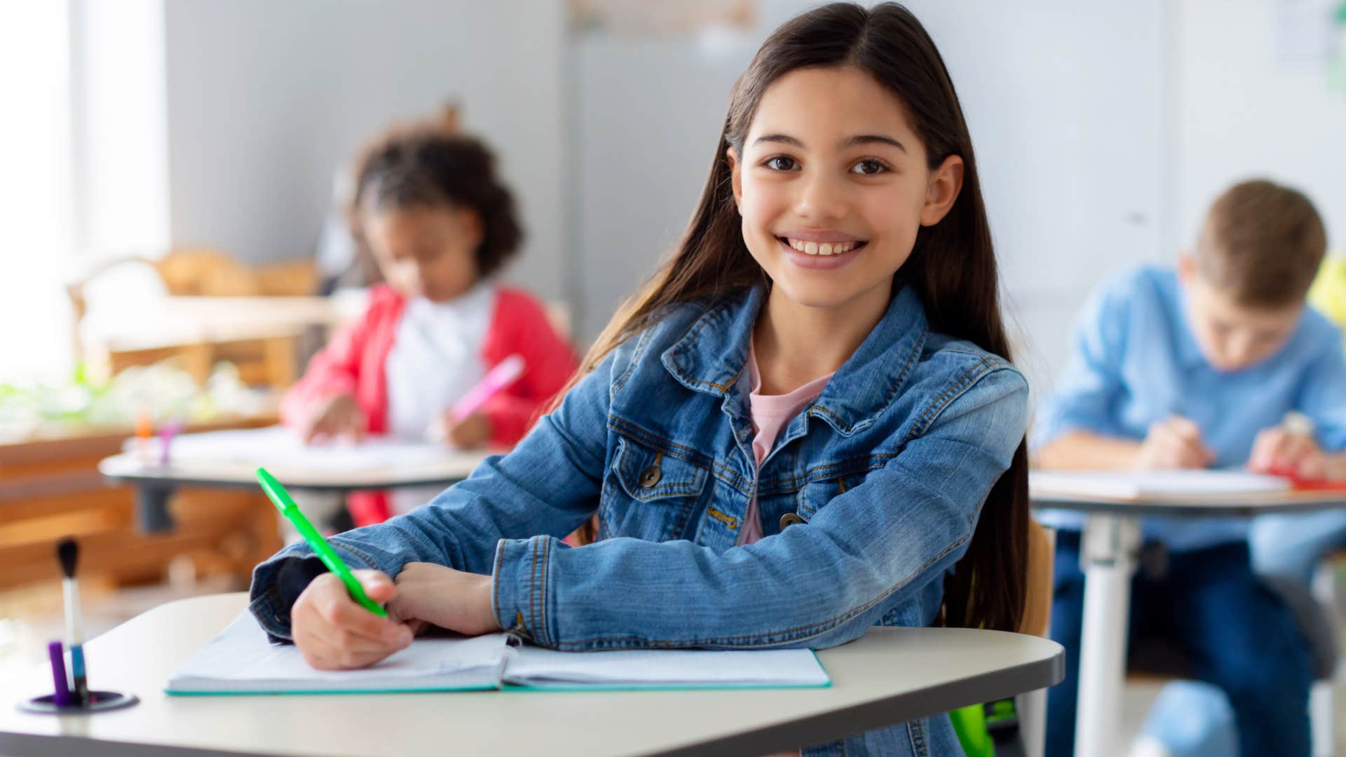 Young student sitting at her desk and smiling.