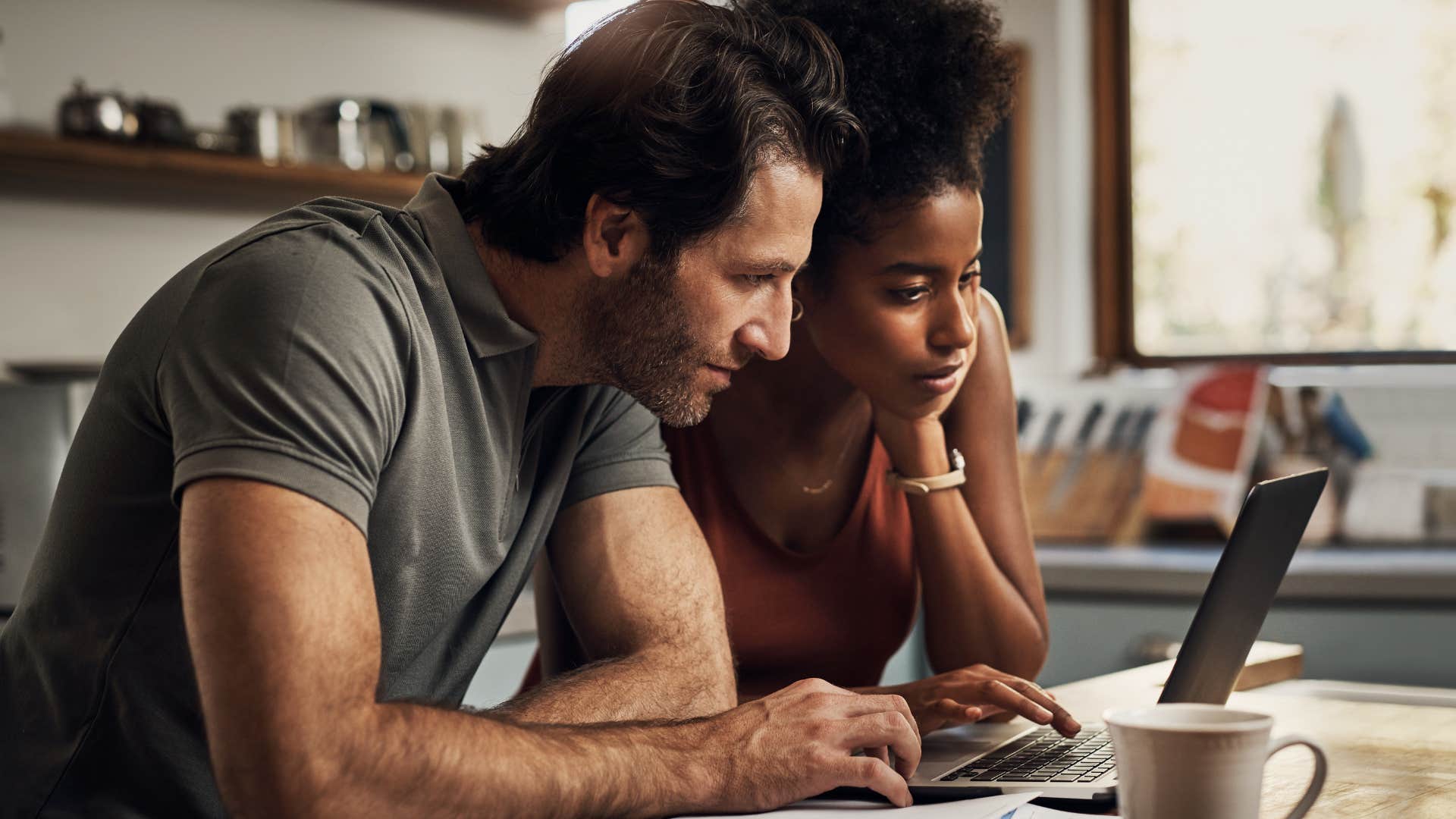 Couple looking concerned while doing their bills in the kitchen