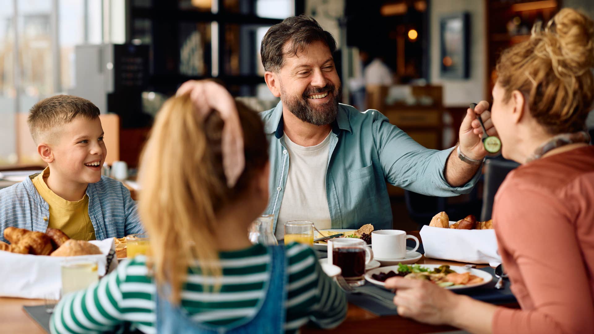 Family smiling and eating together at a restaurant