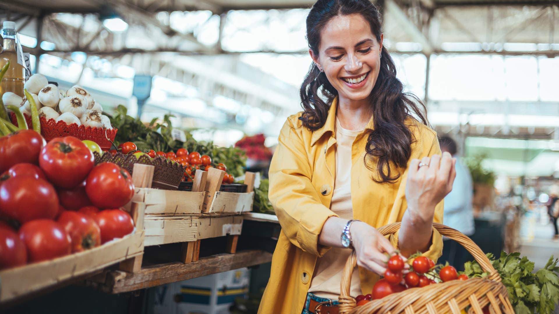 Woman smiling while walking through a farmers' market