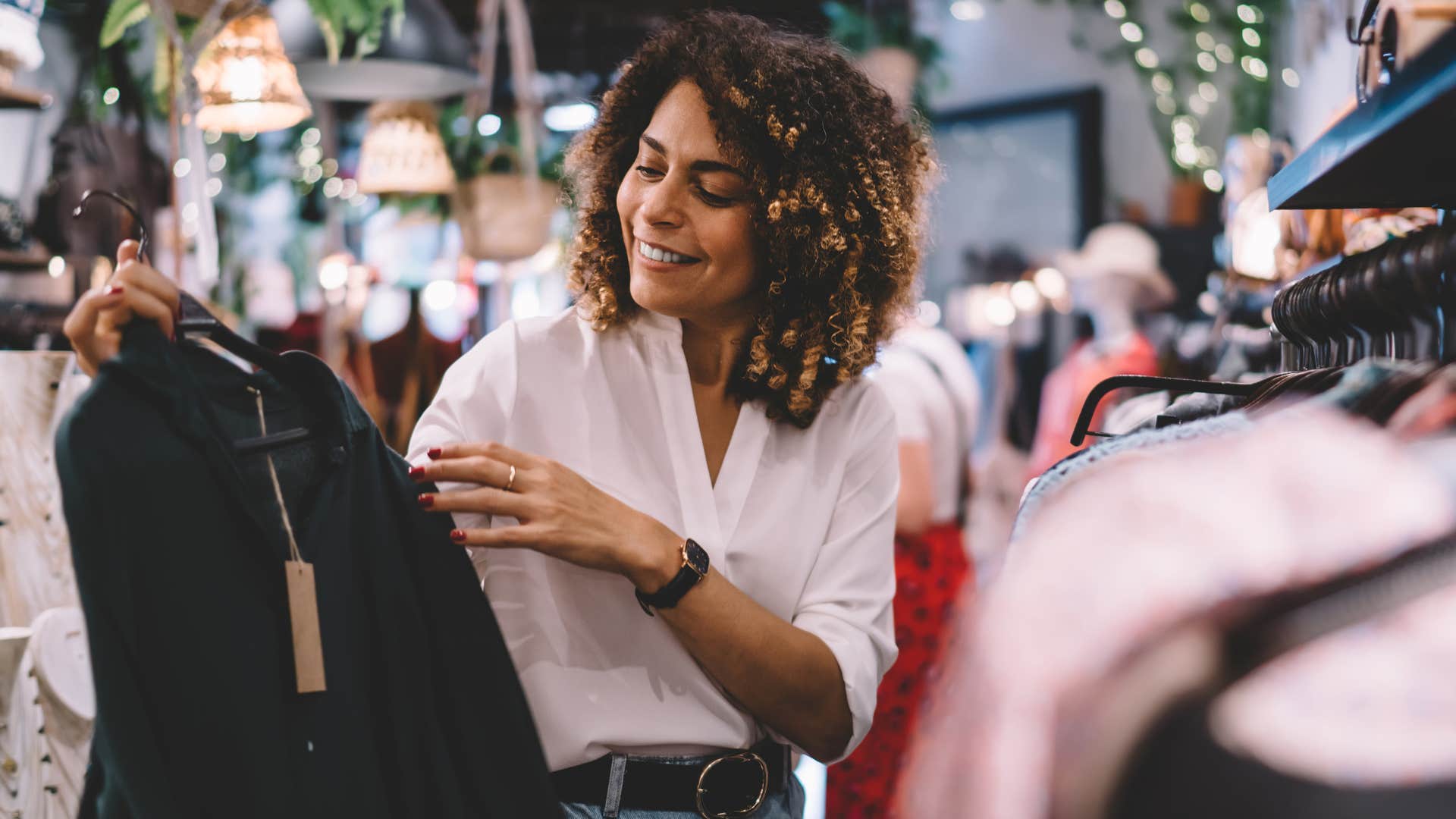 Woman smiling while looking at clothes in a store