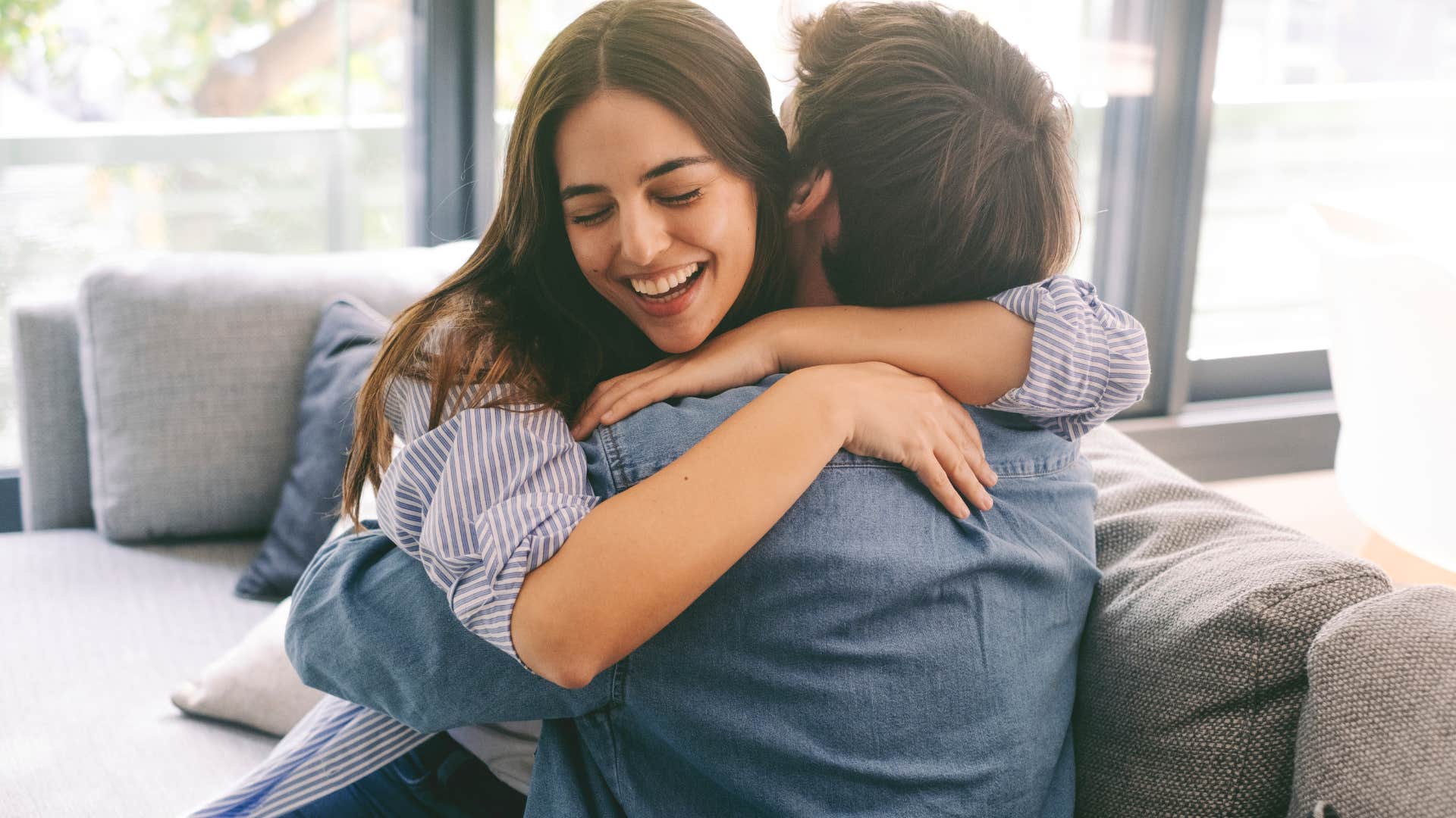 Woman smiling and hugging a man.