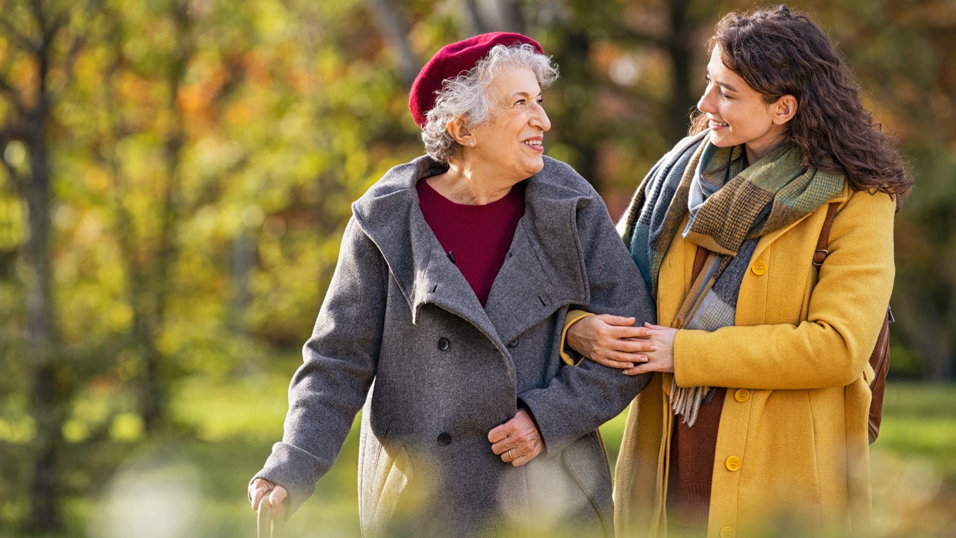 Old and young woman walking together outside.