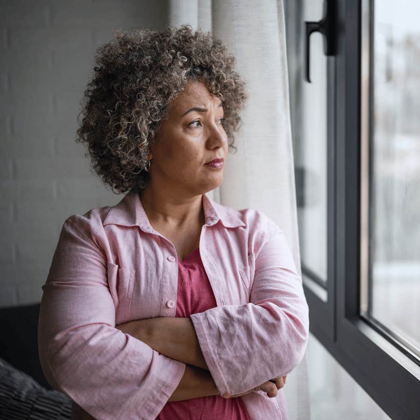 thoughtful older woman staring out of window