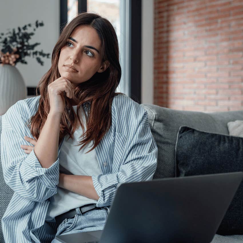 thoughtful woman with an open laptop