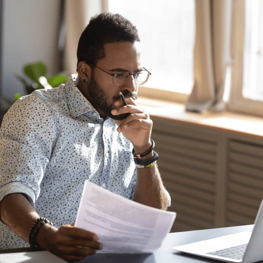 thoughtful young man staring at a laptop