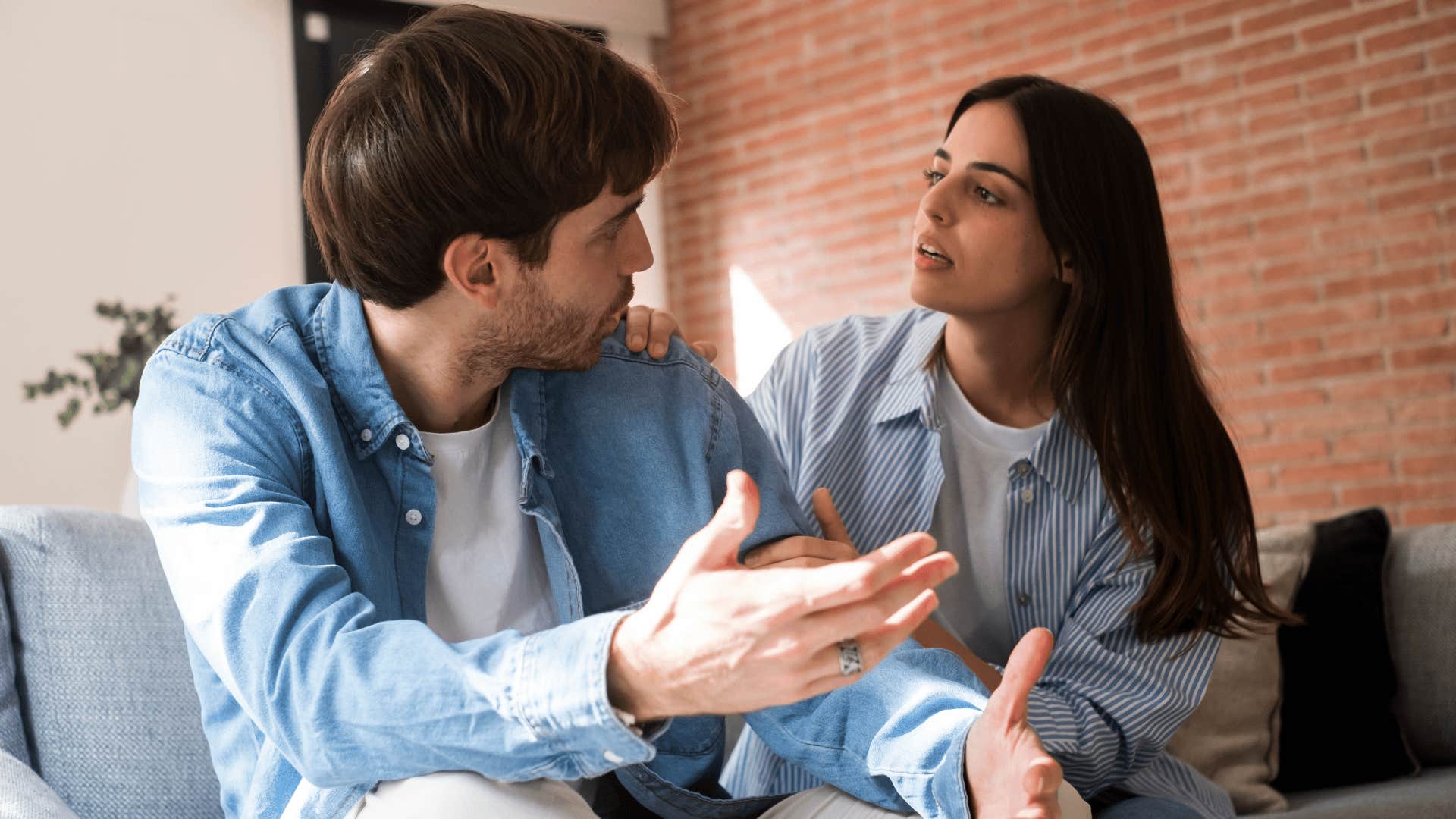 man and woman arguing on couch