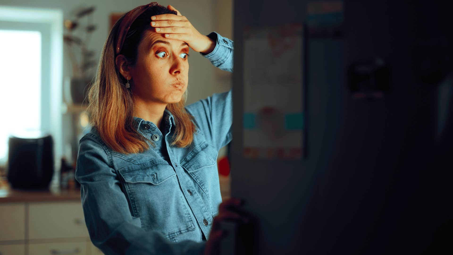 woman looking through fridge not knowing what she wants