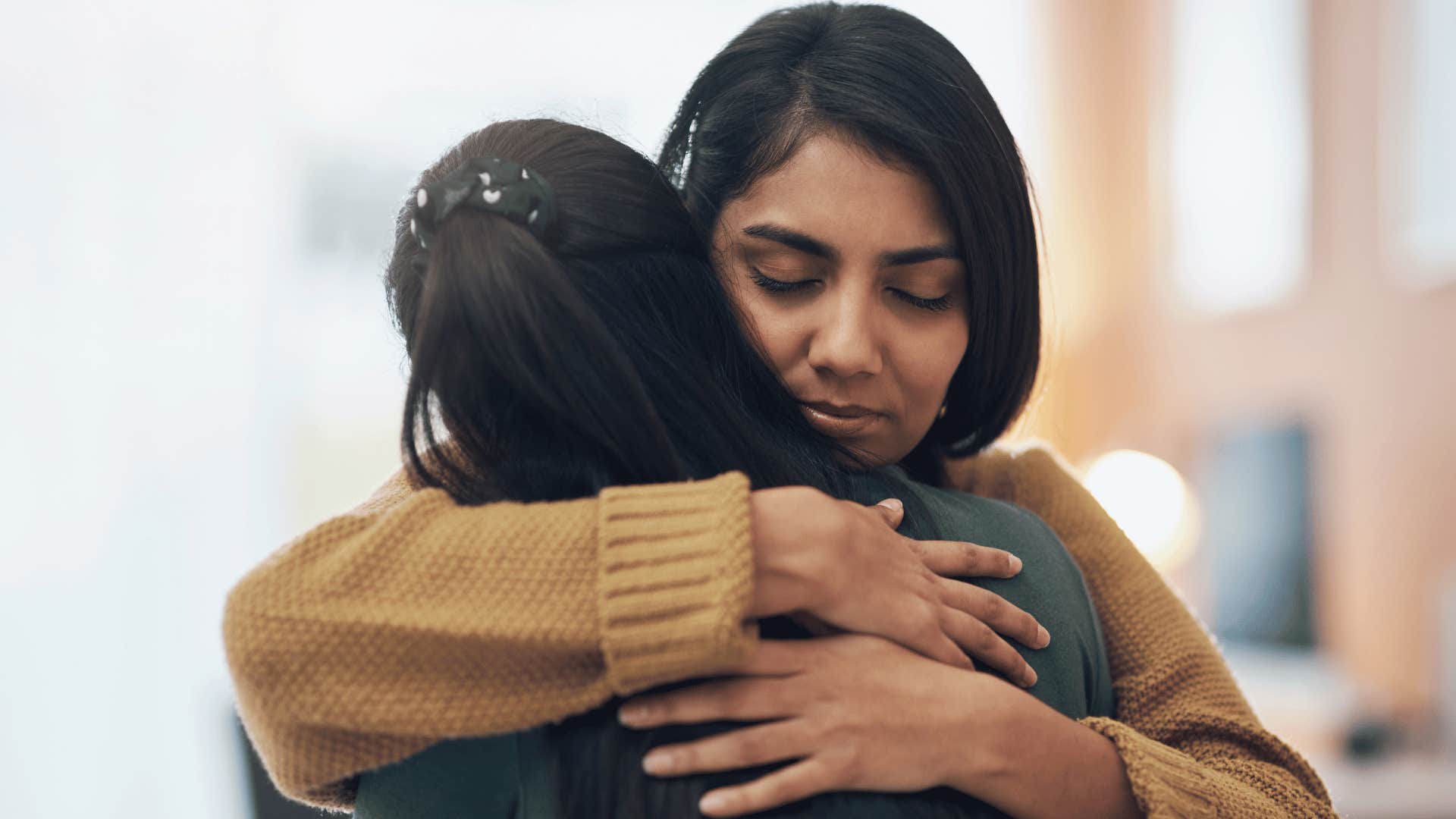 two women hugging outside 