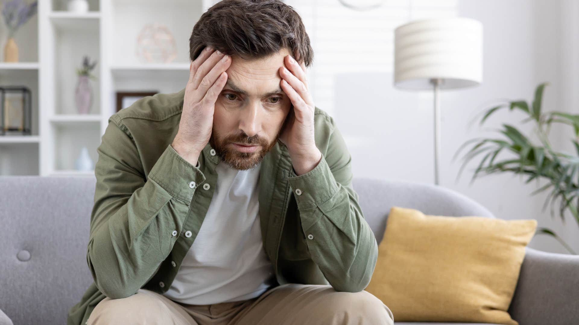 emotionally stunted man looking frustrated sitting on the couch