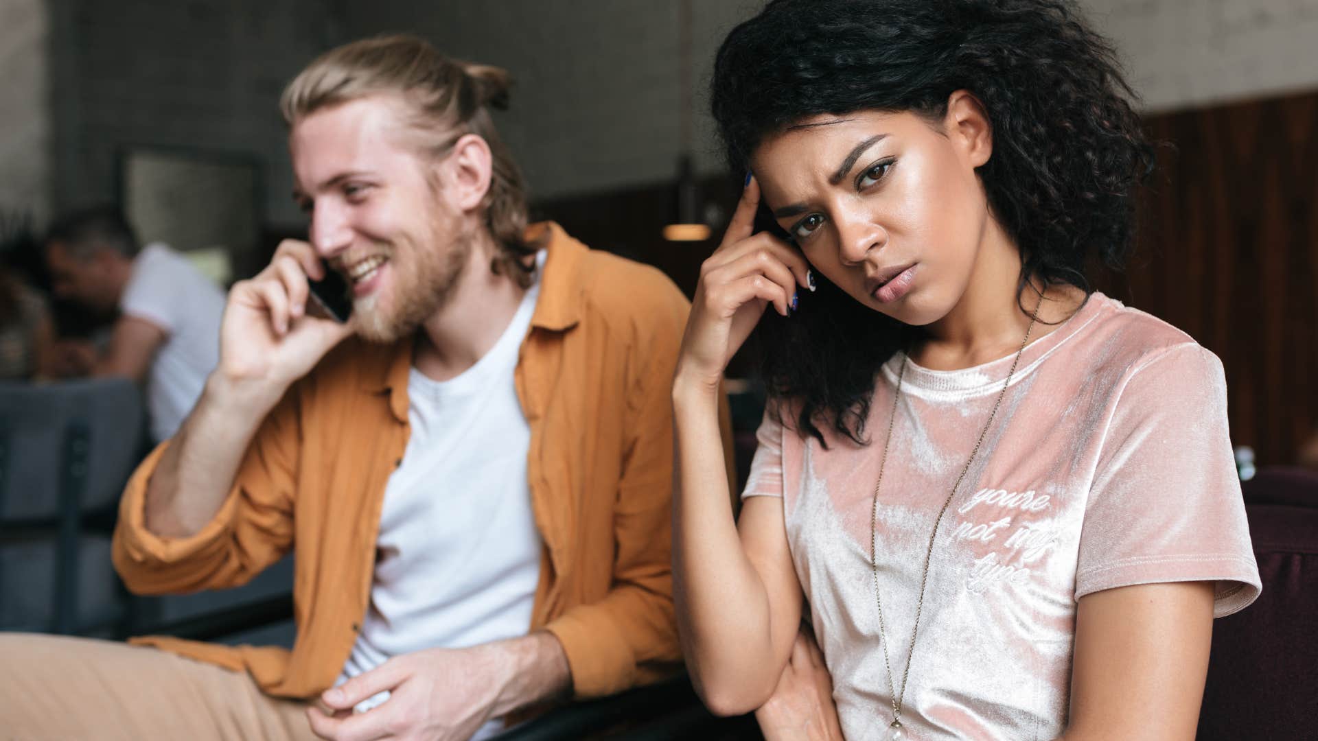 woman annoyed while emotionally stunted man talks on the phone