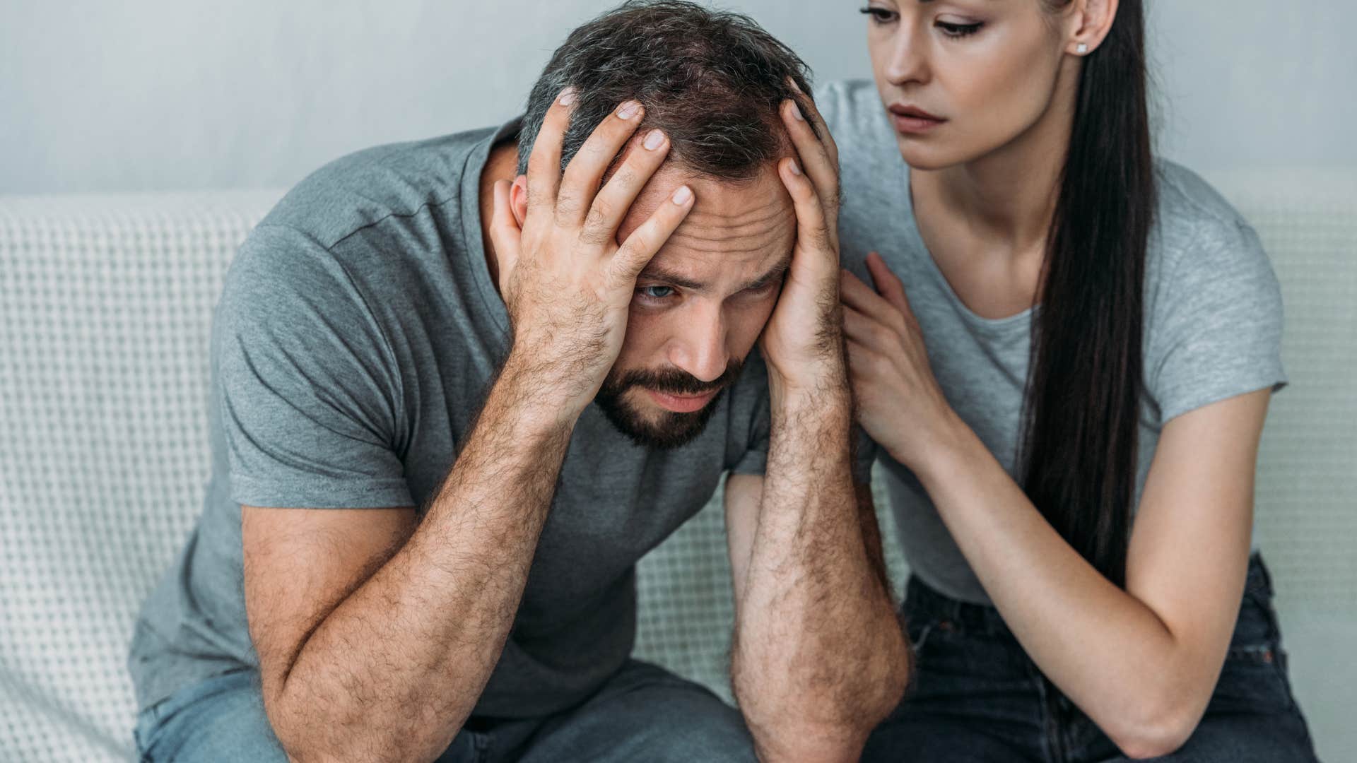 emotionally stunted man holding his head in his hands