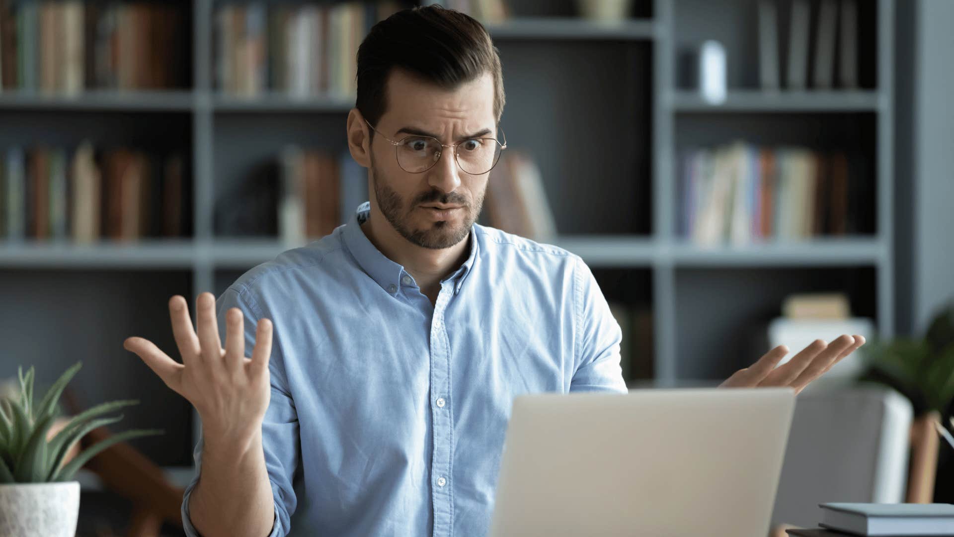 man looking perplexed at his laptop 