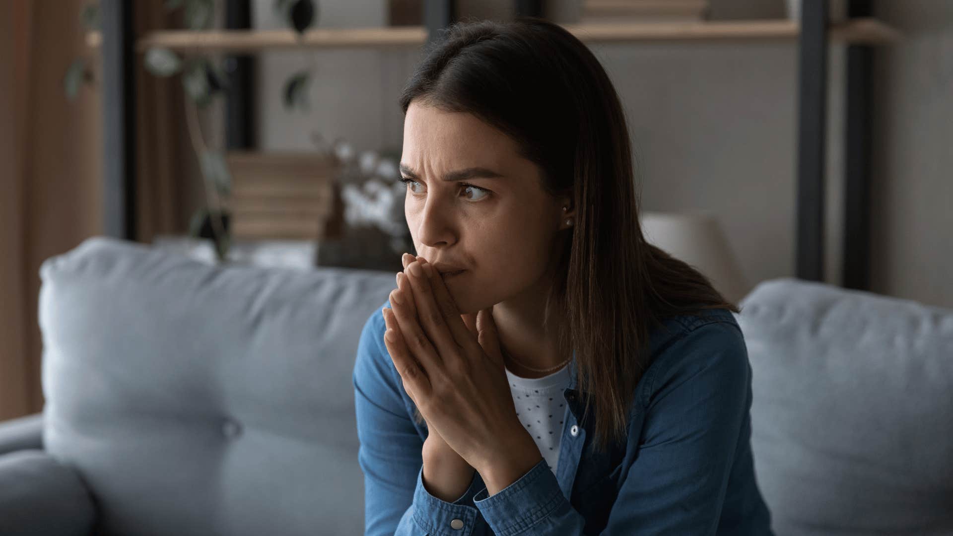 woman thinking while sitting on couch