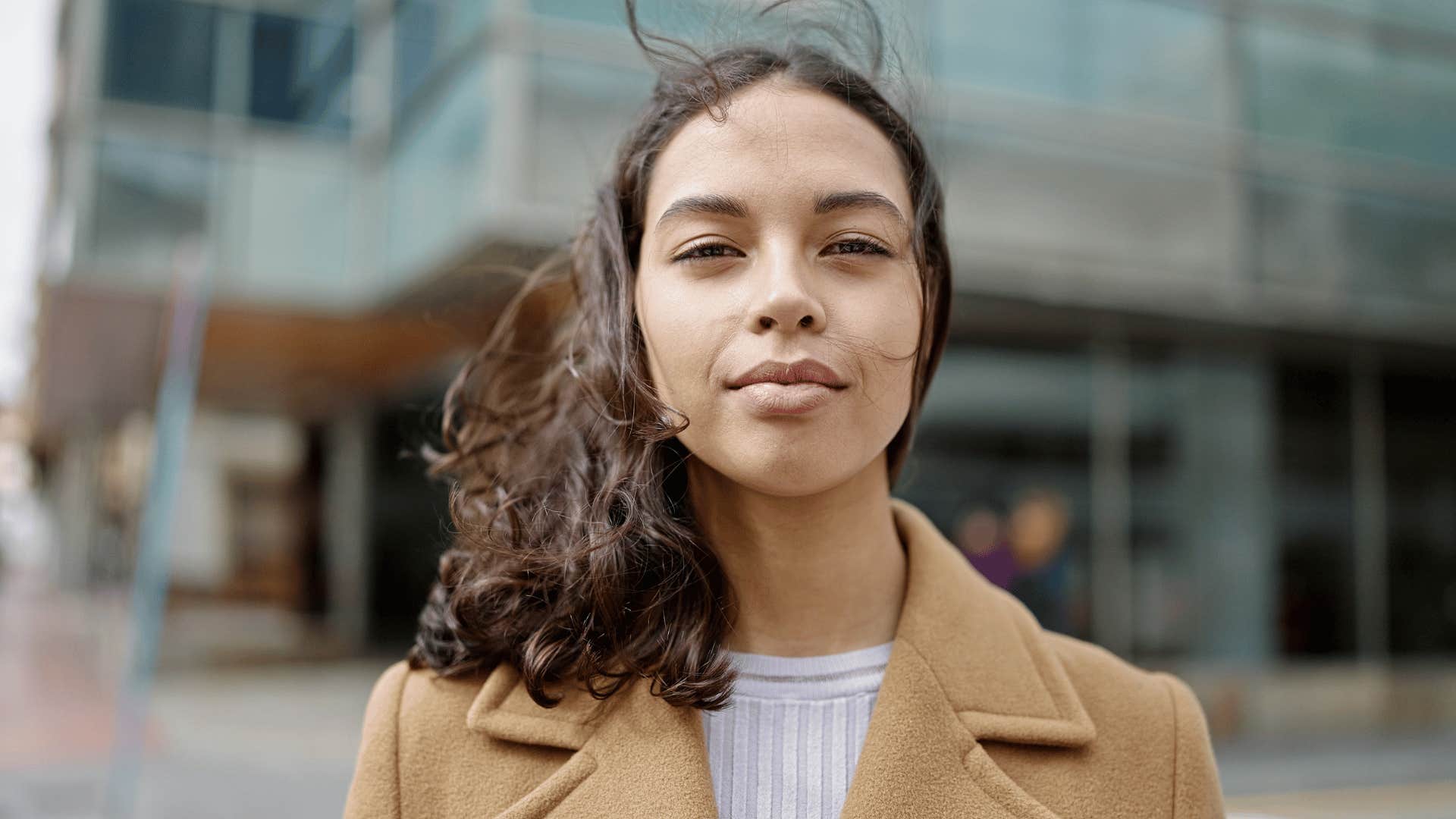 One a street corner, she stares sternly into the camera