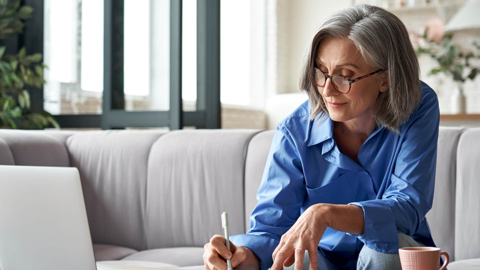 Older woman smiling and writing on a piece of paper