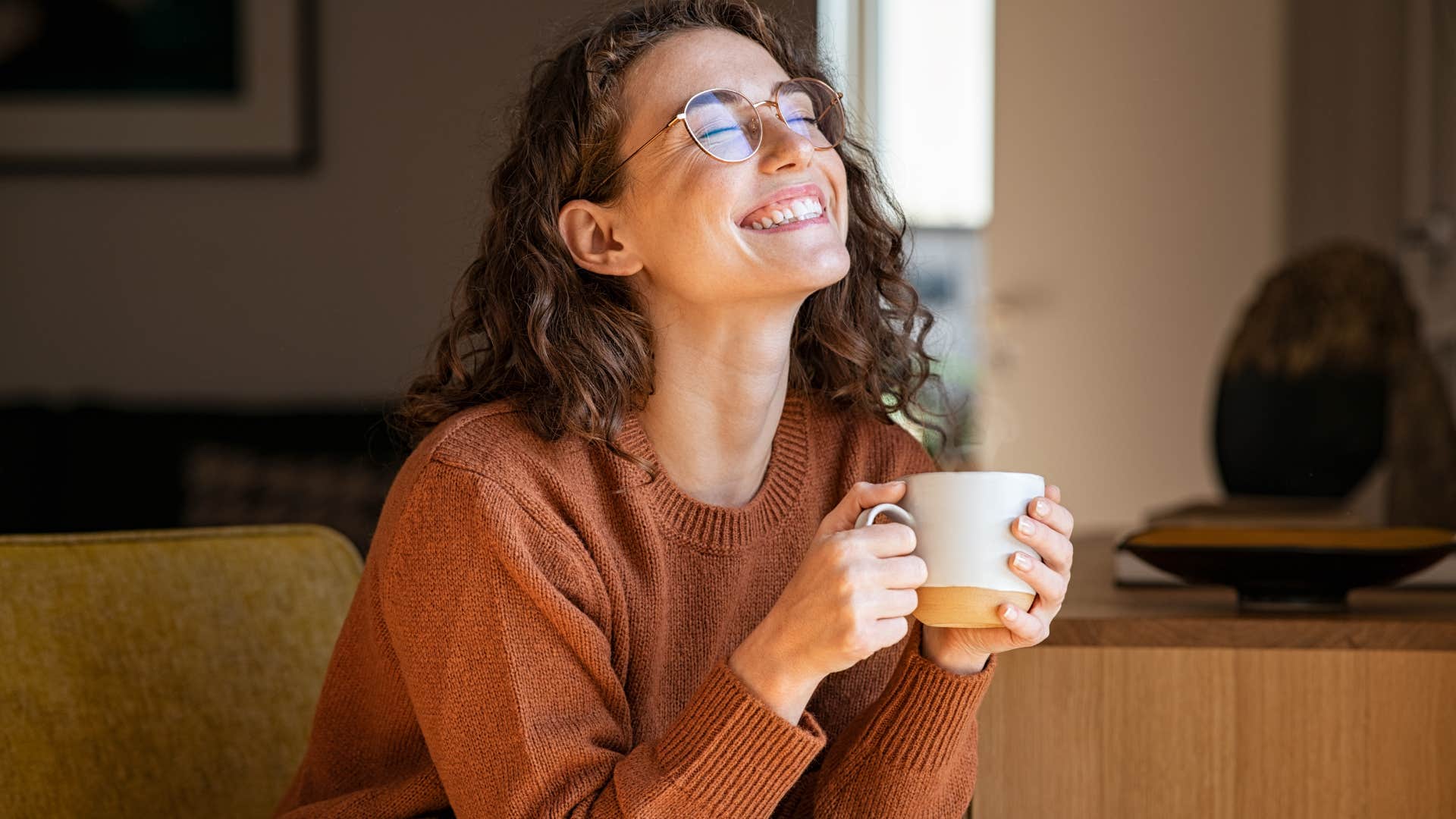 Woman smiling and holding a cup of coffee