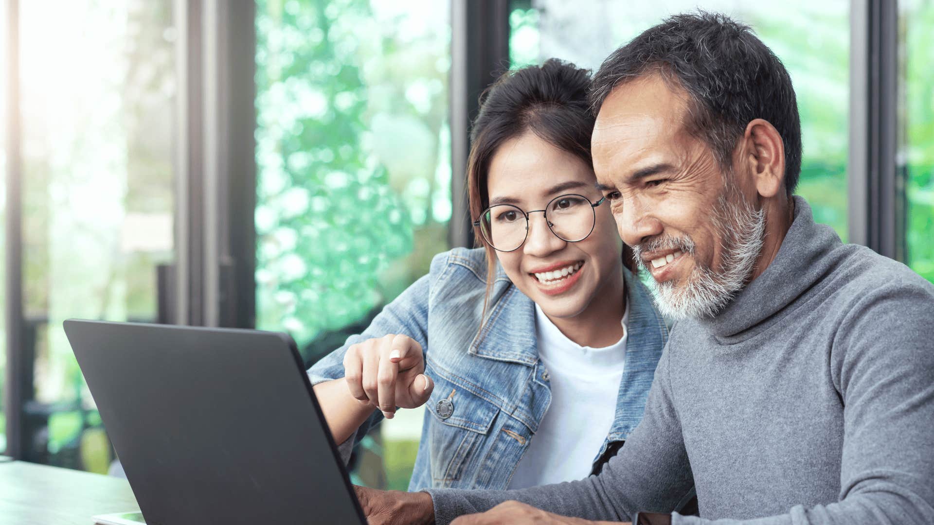 grandpa and granddaughter working on laptop