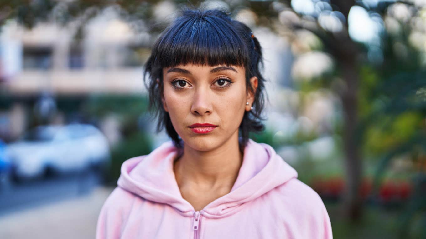 young serious woman in pink sweater