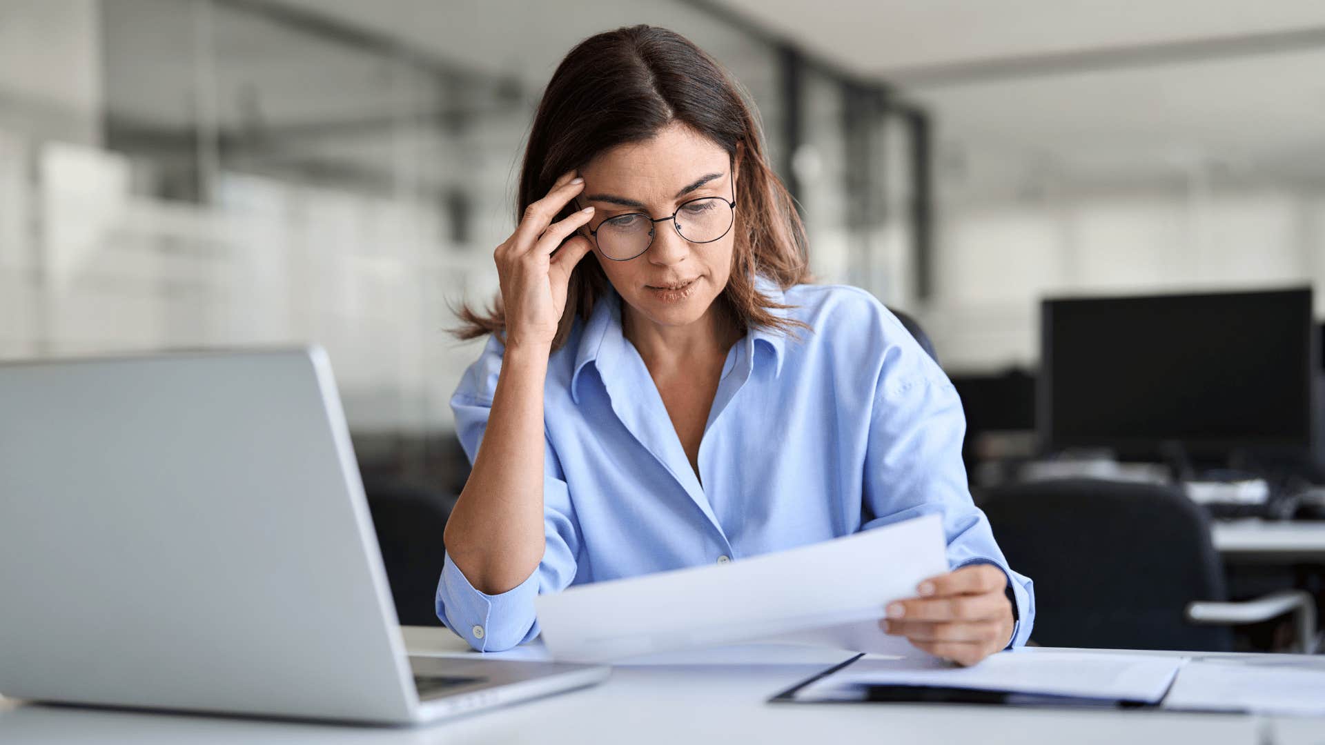 woman looking at paper frustrated 