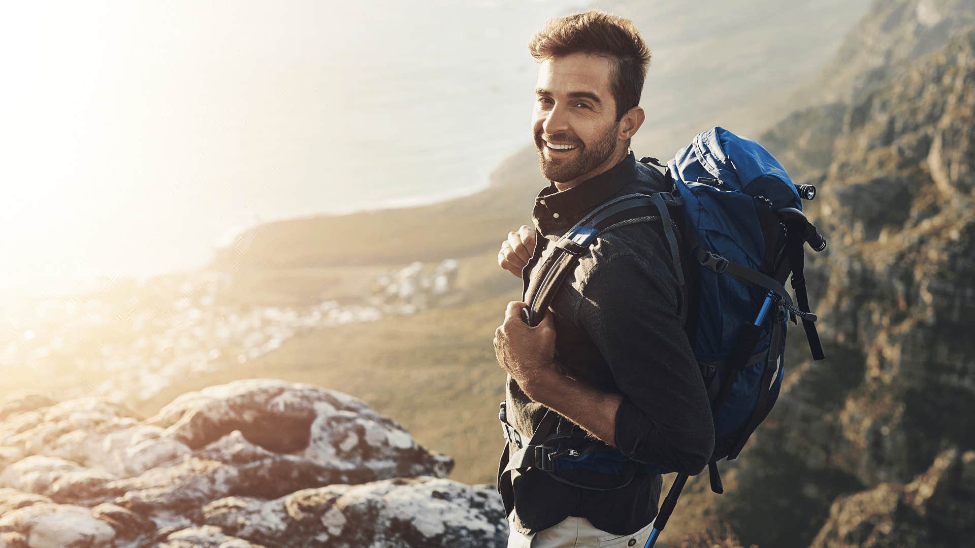 man hiking and looking at camera