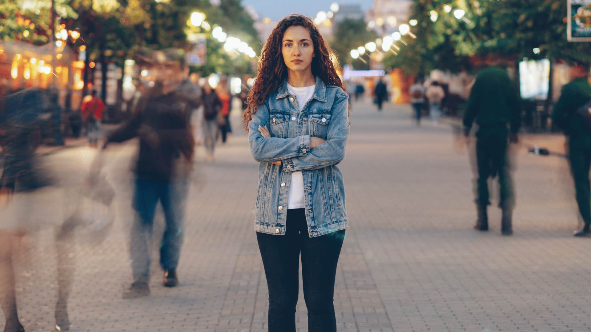 woman standing alone as crowd passes her by