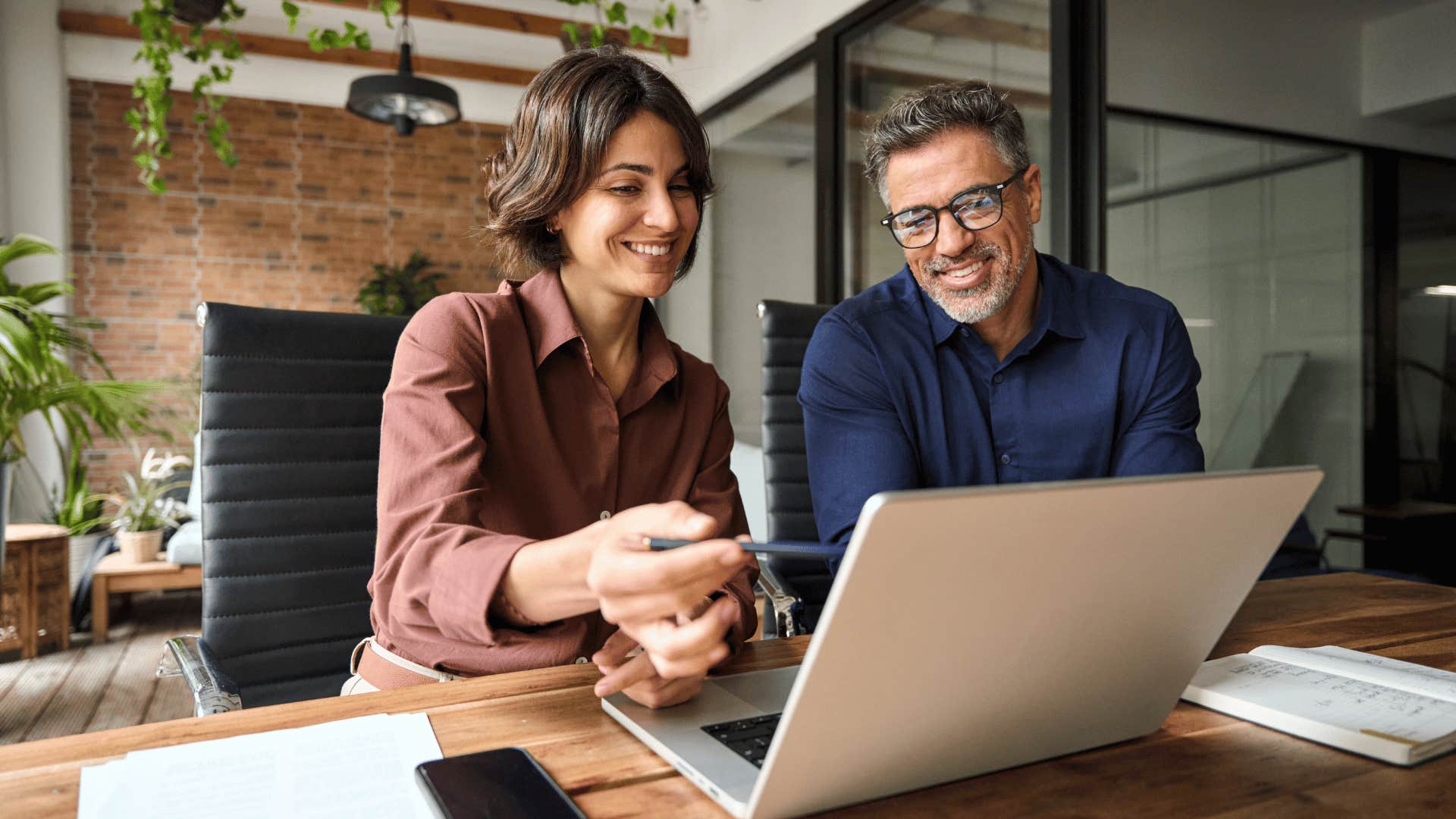 man and woman looking at laptop and discussing 