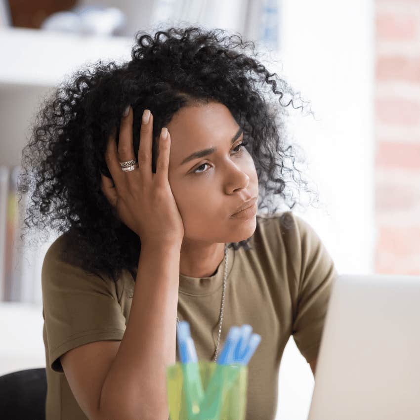 unmotivated and uninspired young woman with a laptop