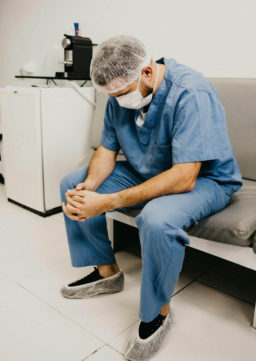 upset nurse sitting down looking at the ground