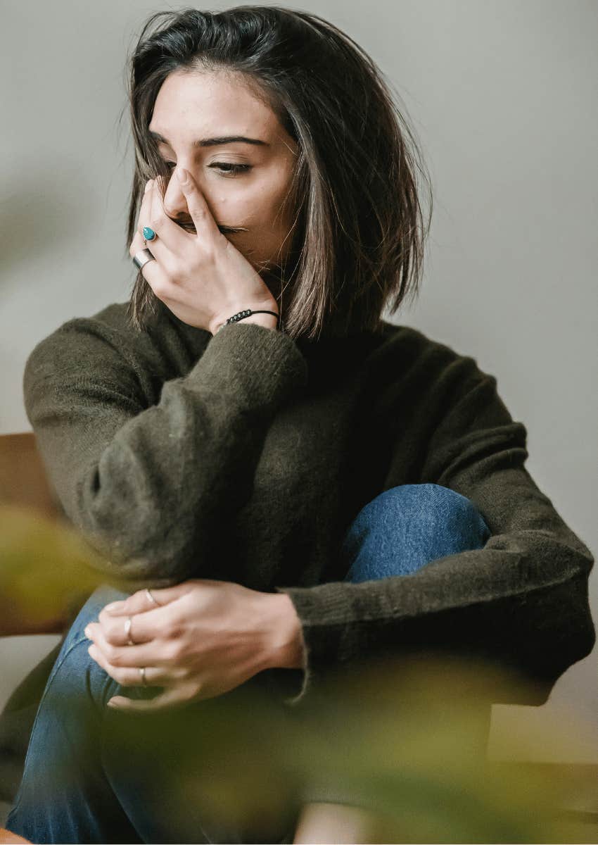 upset young woman hugging her knees to her chest