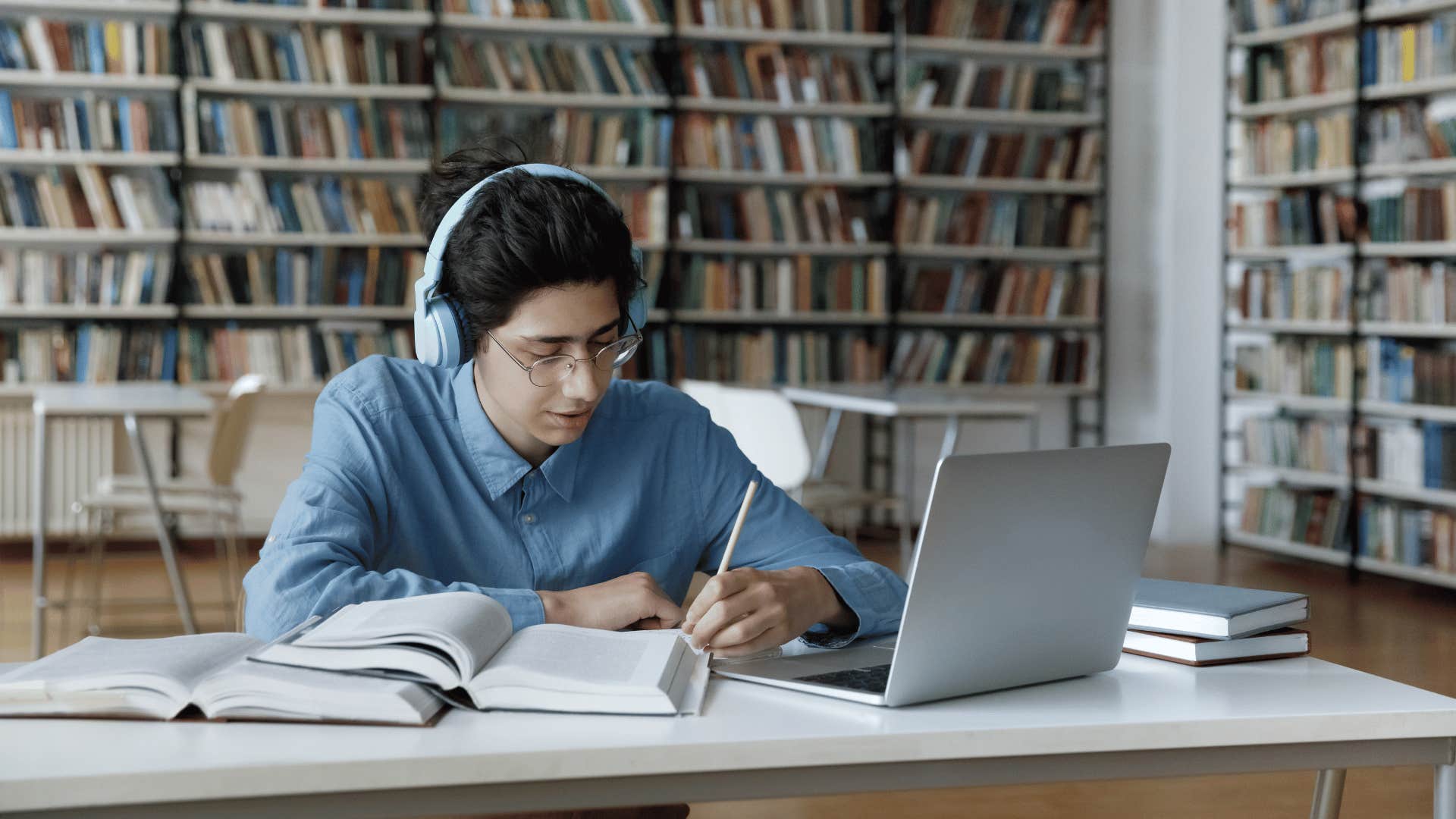 man working hard on assignments in library 