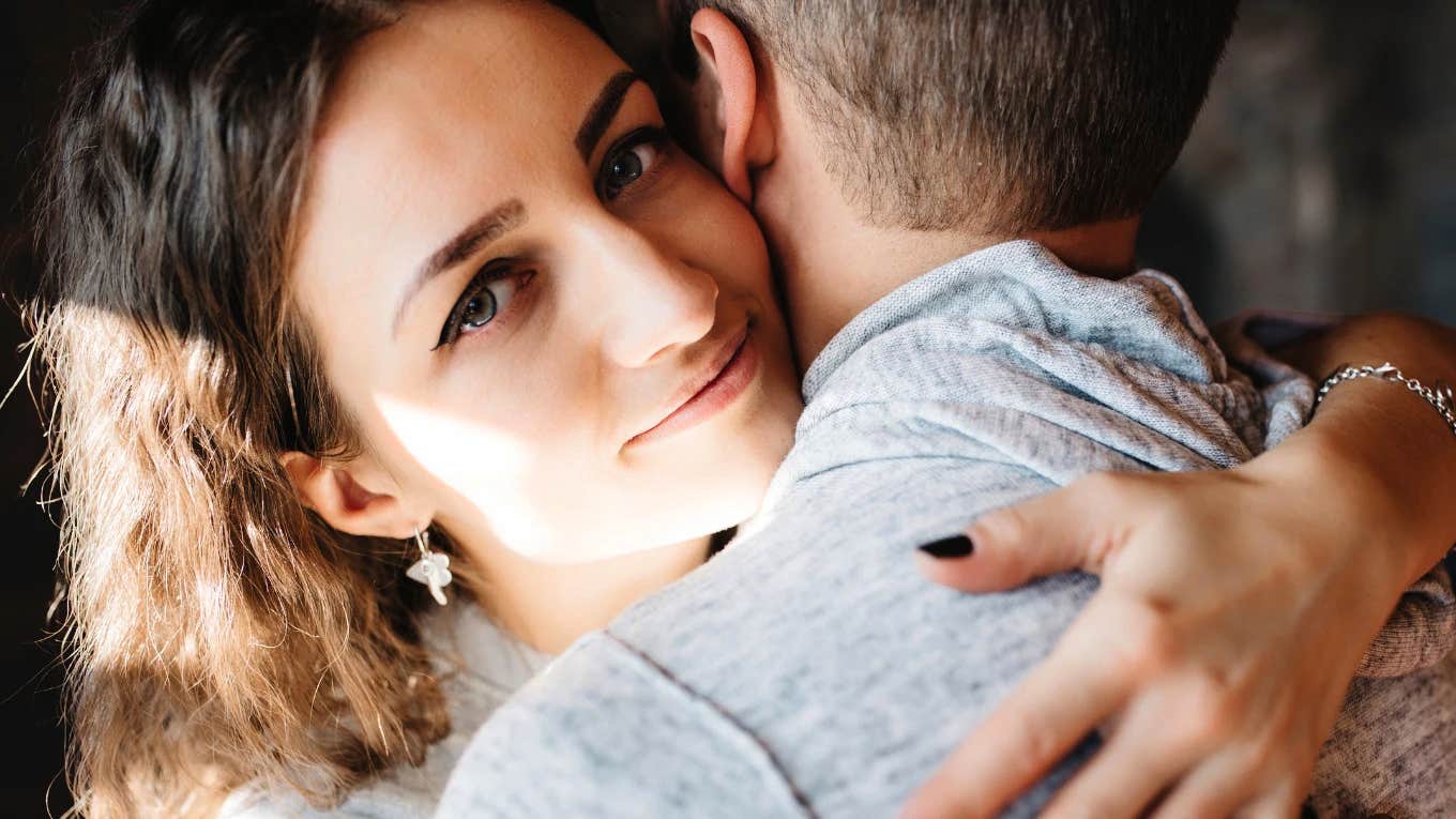 Wife encouraging her husband to be more emotionally vulnerable with a hug.