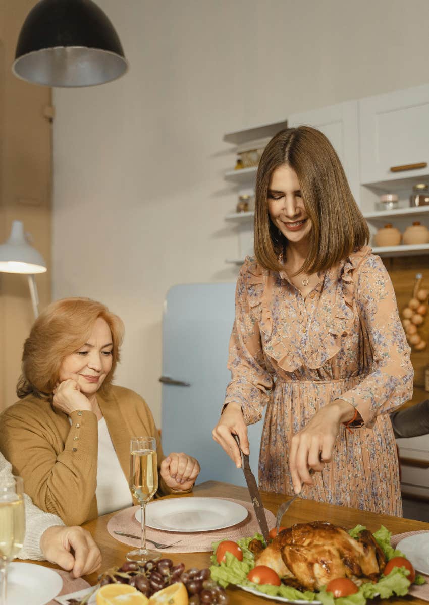 woman carving Thanksgiving turkey next to her mom