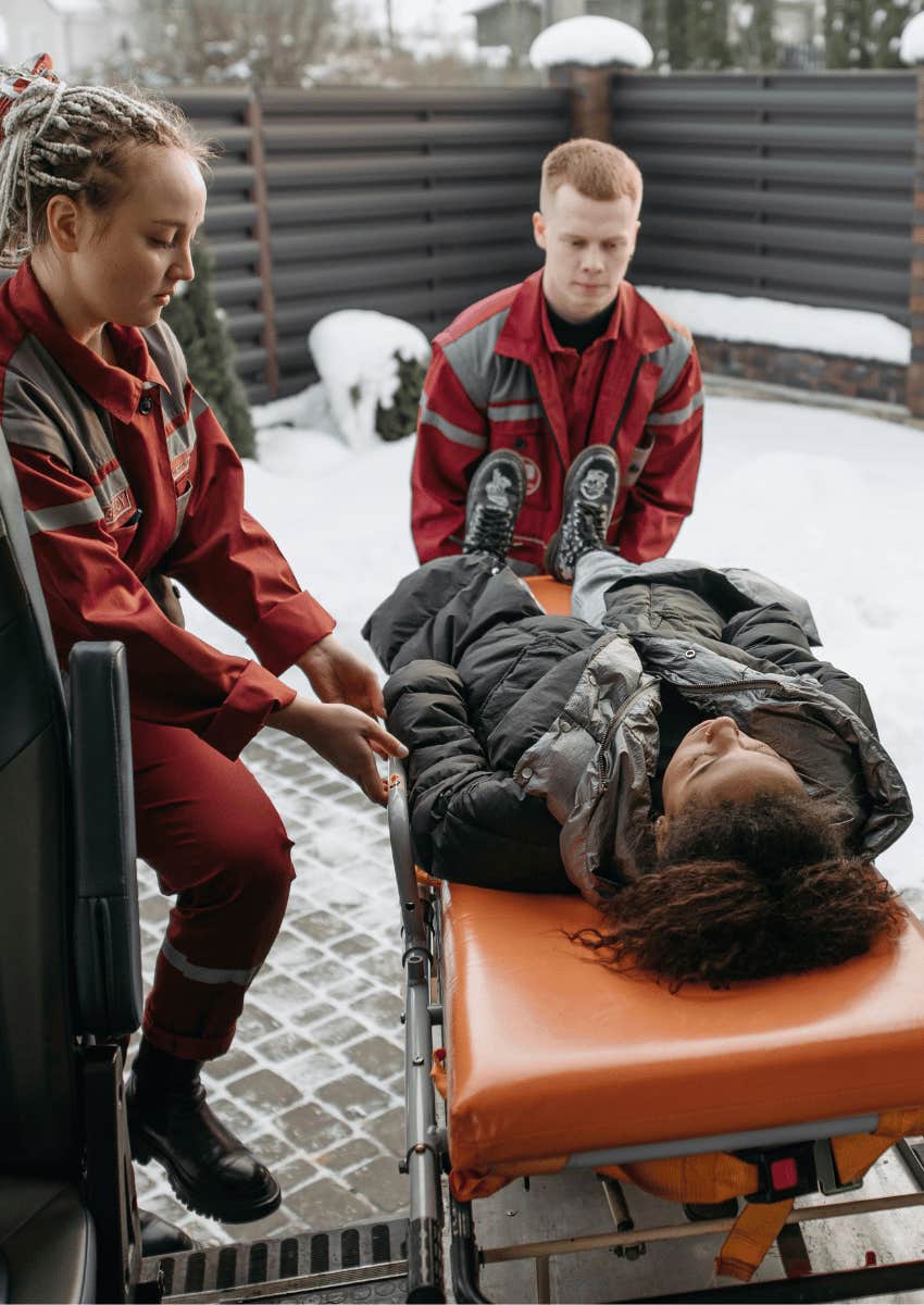 woman on a gurney being helped by emergency response people