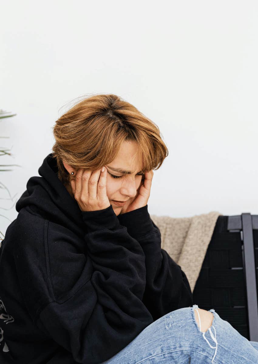 woman with a headache rubbing her temples